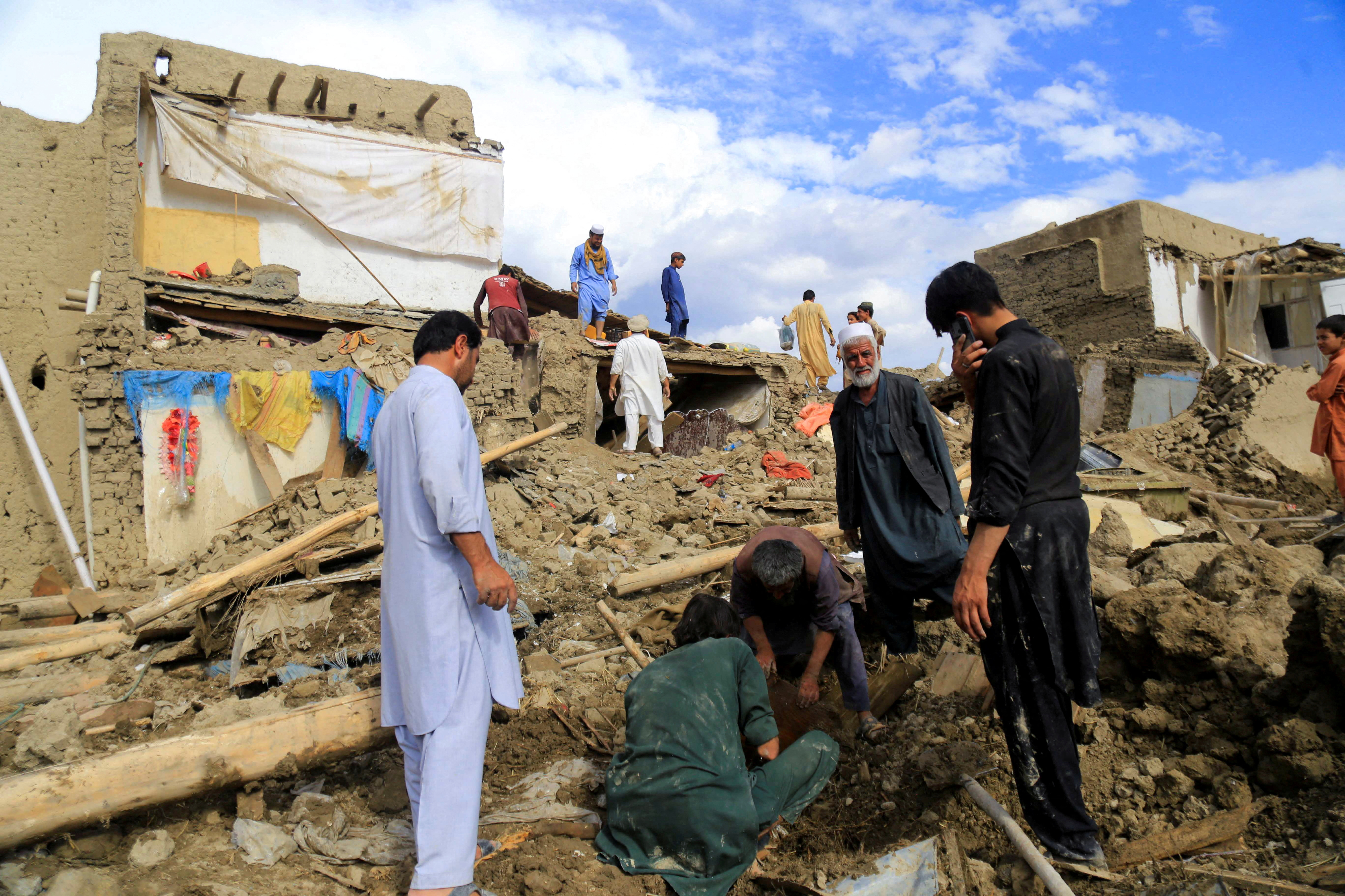 People clean up their damaged homes after the heavy flood in the Khushi district of Logar