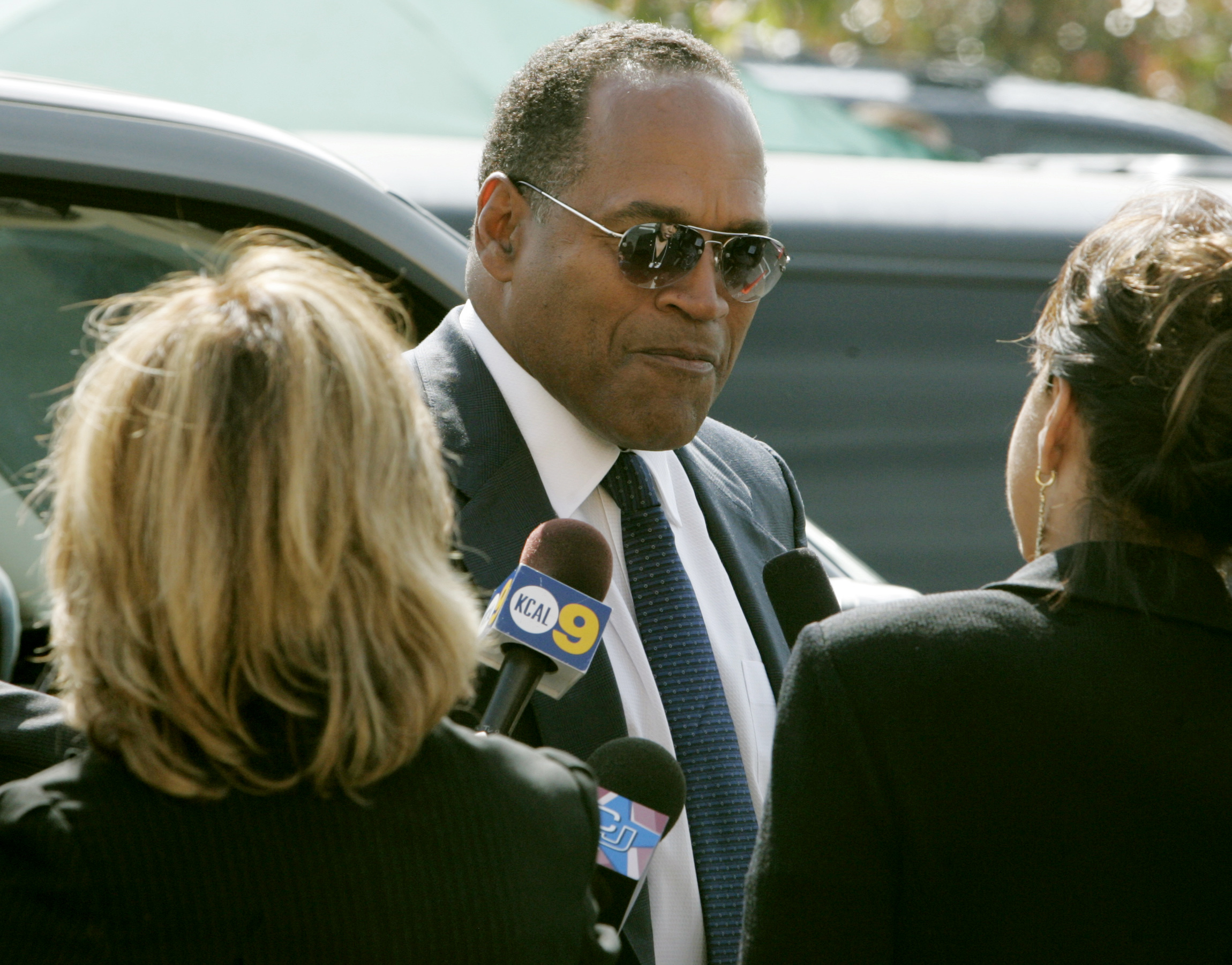O.J. Simpson talks to reporters as he arrives for the funeral of attorney Johnnie Cochran,Jr.