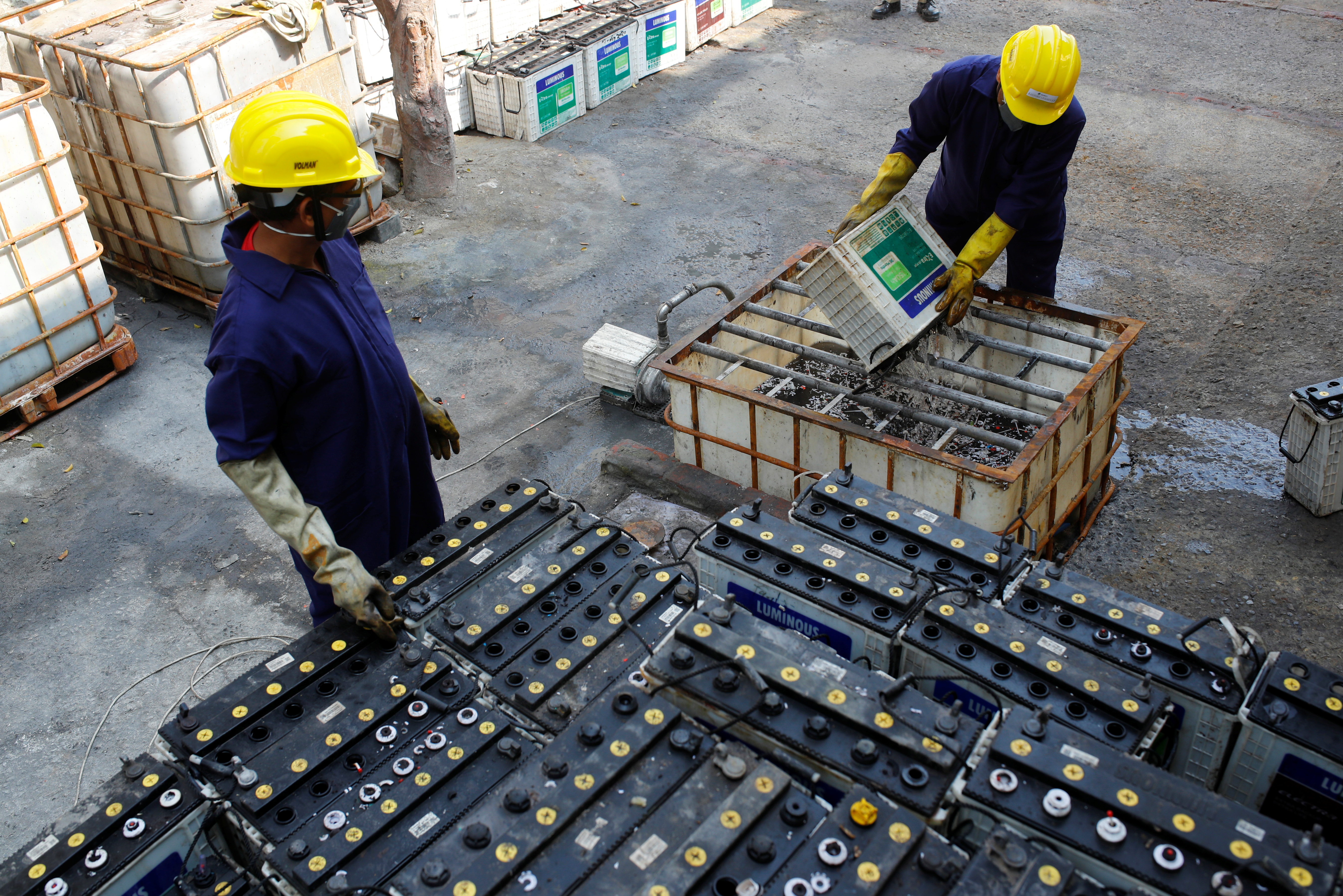 Workers dismantle batteries to obtain lead from them at ACE Green recycling Inc in Ghaziabad