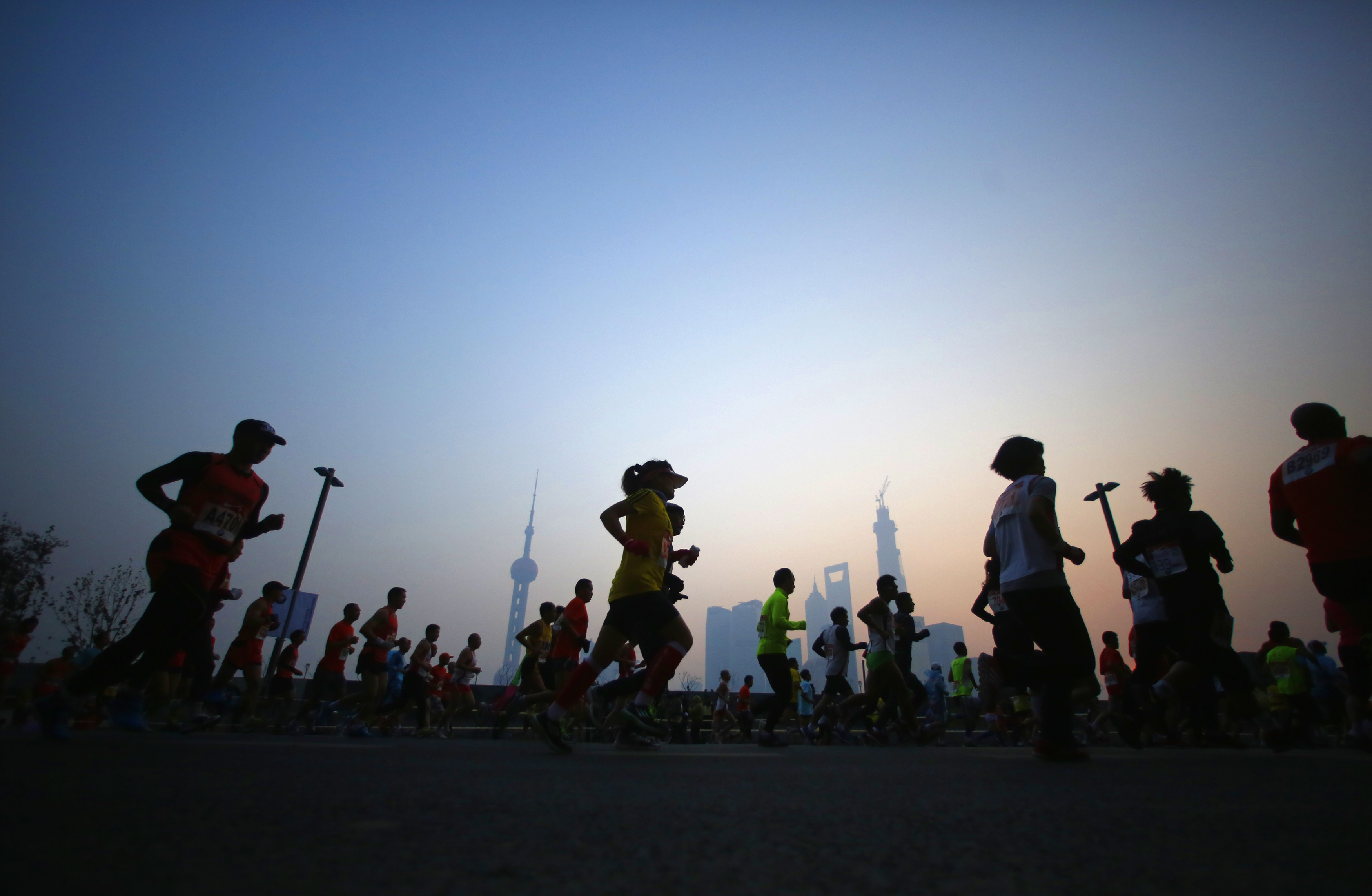 Participants run on the Bund near Huangpu River as they compete in the Shanghai International Marathon