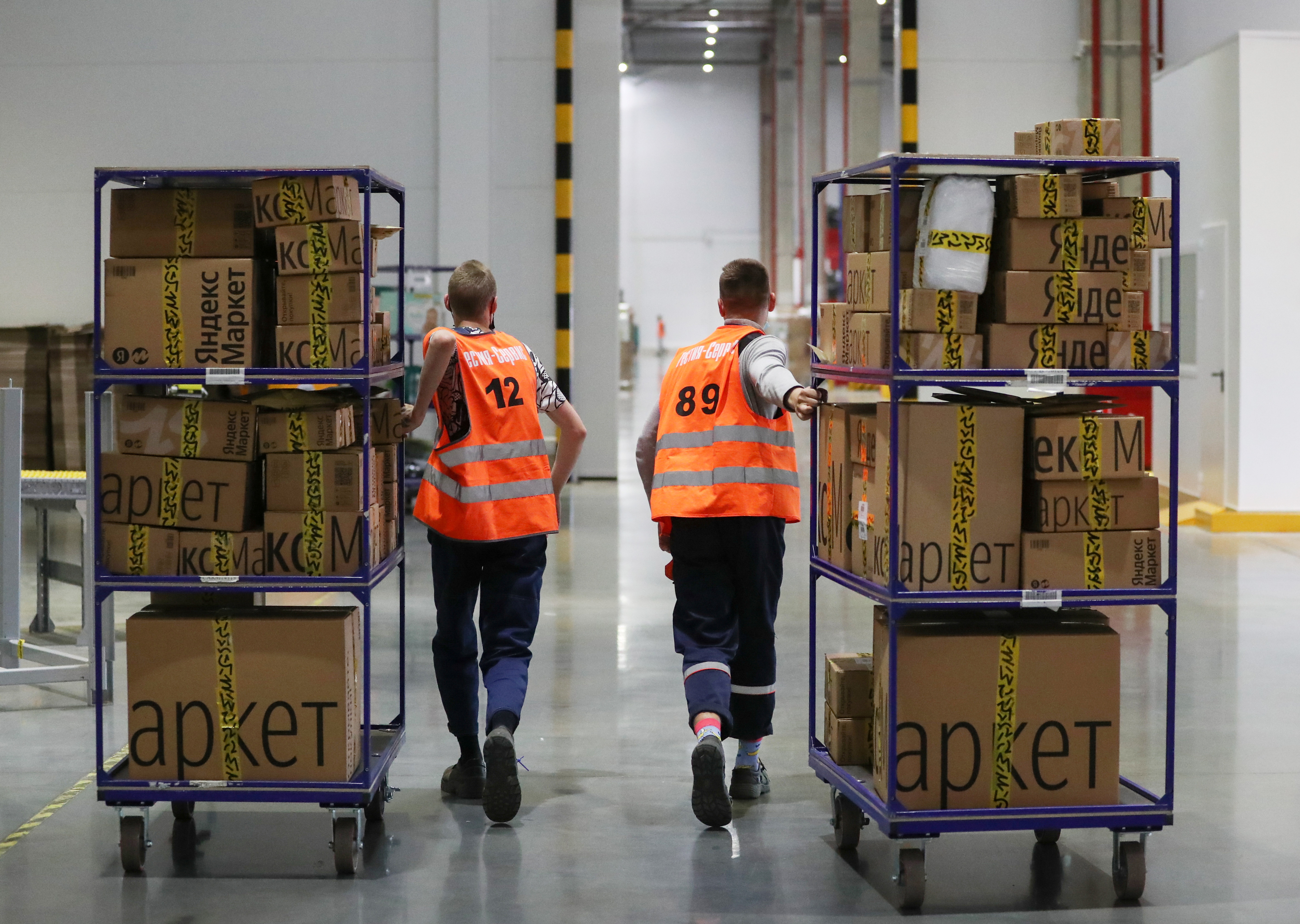 Employees move boxes at a logistics centre of the Yandex.Market e-commerce platform in Moscow