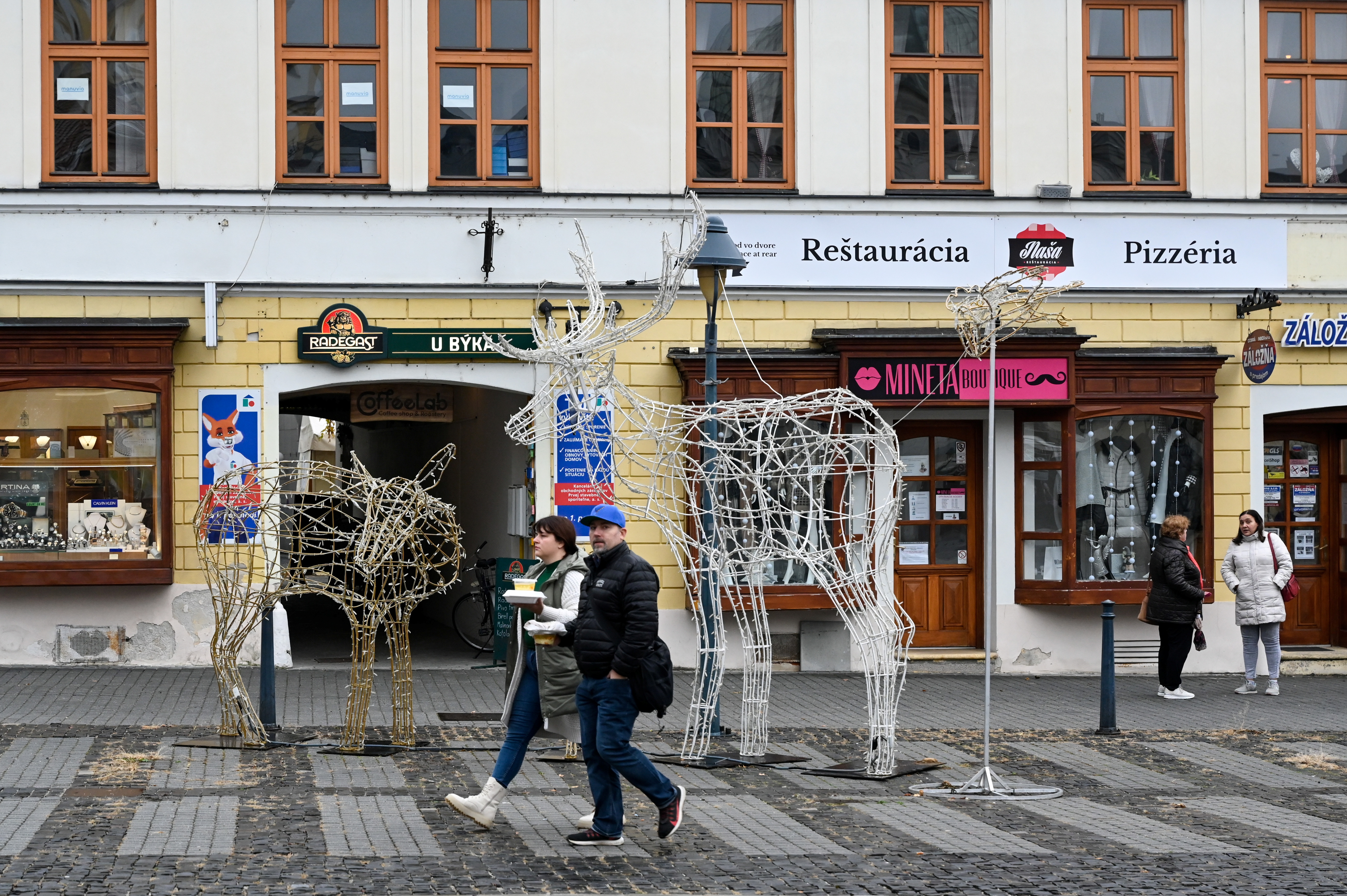 People walk past closed restaurants as the Slovak government mandated further restrictions to curb the spread of the coronavirus disease (COVID-19), in Trencin, Slovakia, November 25, 2021. REUTERS/Radovan Stoklasa
