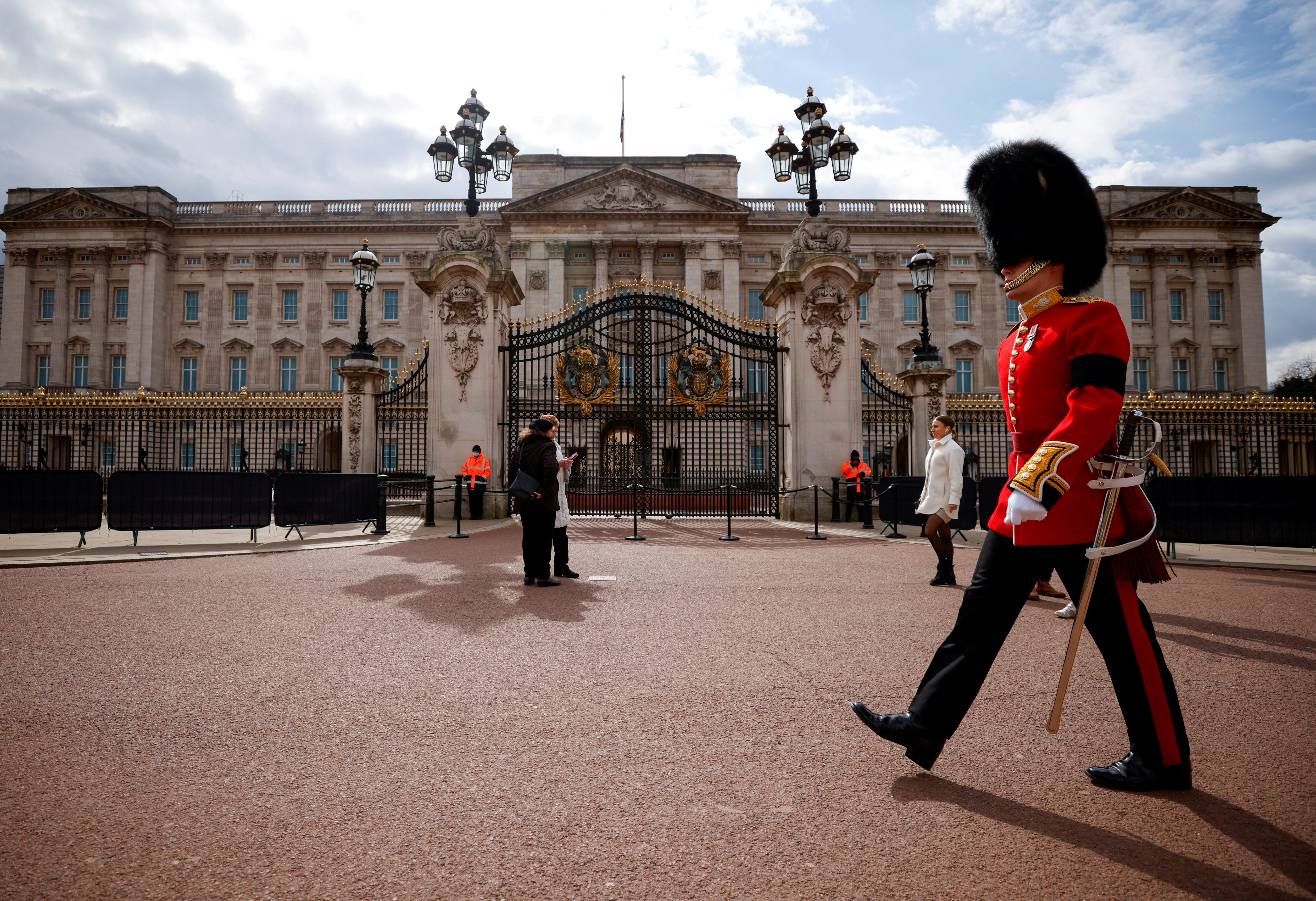 A guardsman walks outside Buckingham Palace in London