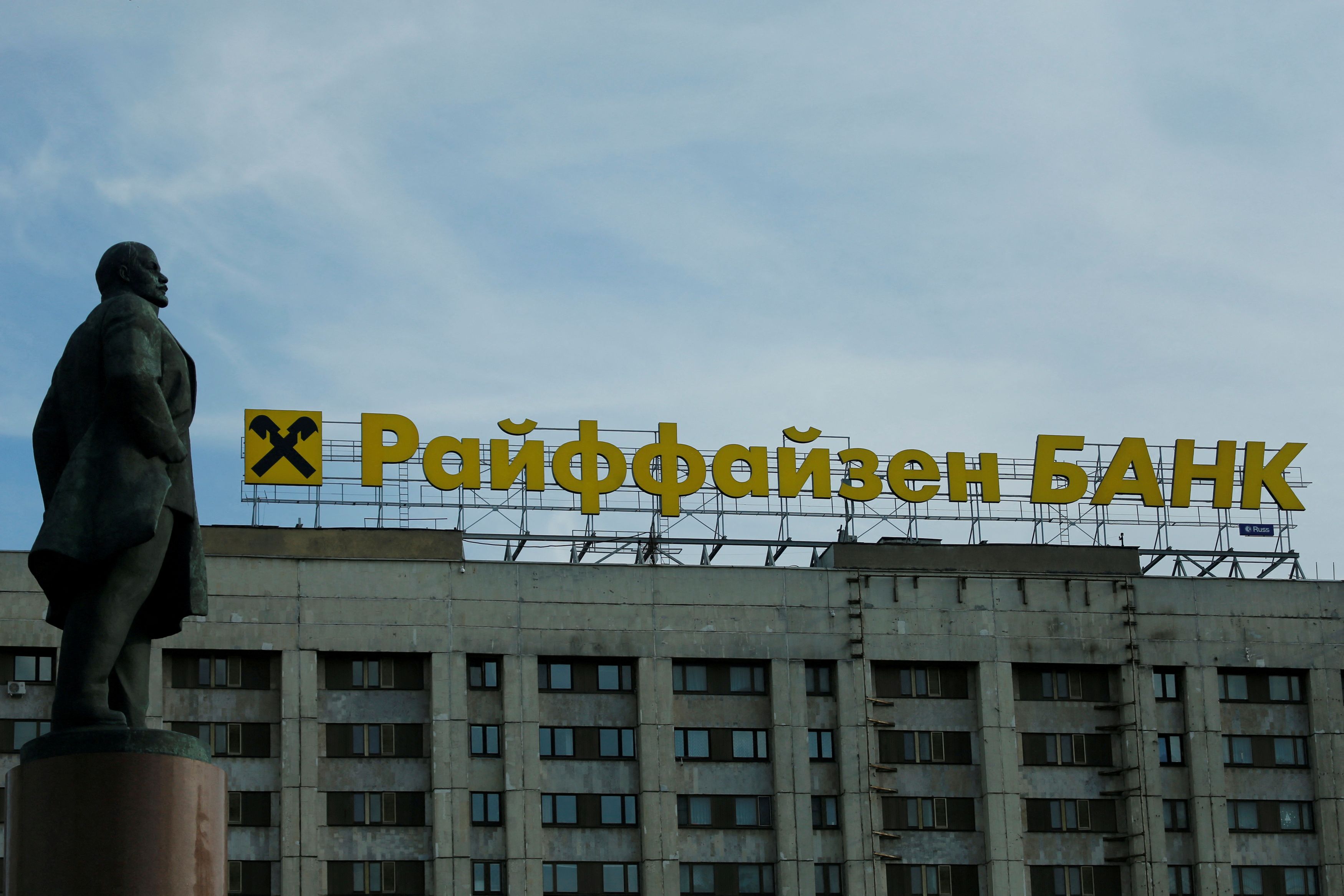 Logo of Raiffeisen Bank on top of building is seen behind statue of Soviet state founder Leninin Moscow