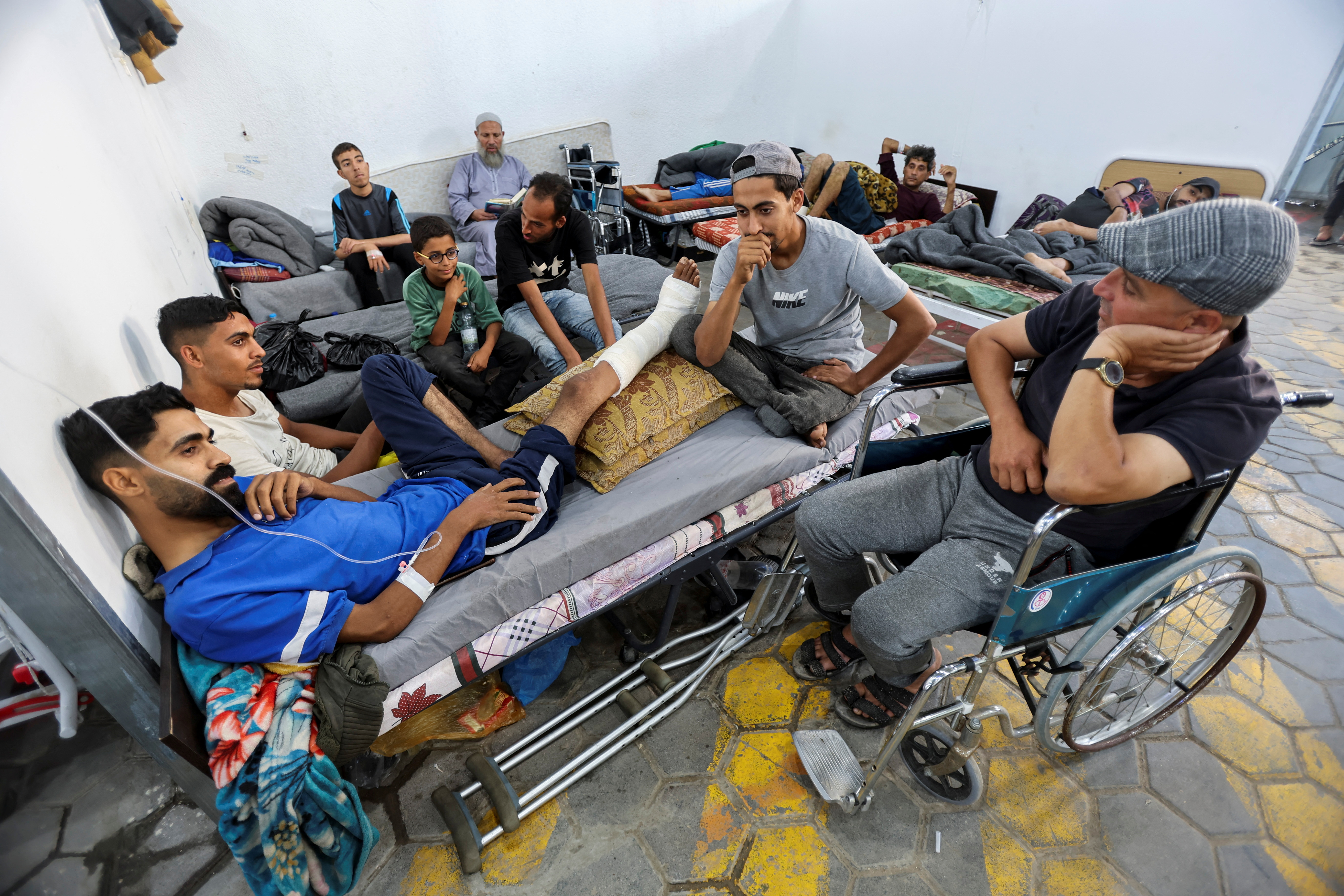 Palestinian man, who was wounded in Israeli fire, lies on a bed as he receives treatment at Al-Aqsa hospital in Deir Al-Balah in the central Gaza Strip