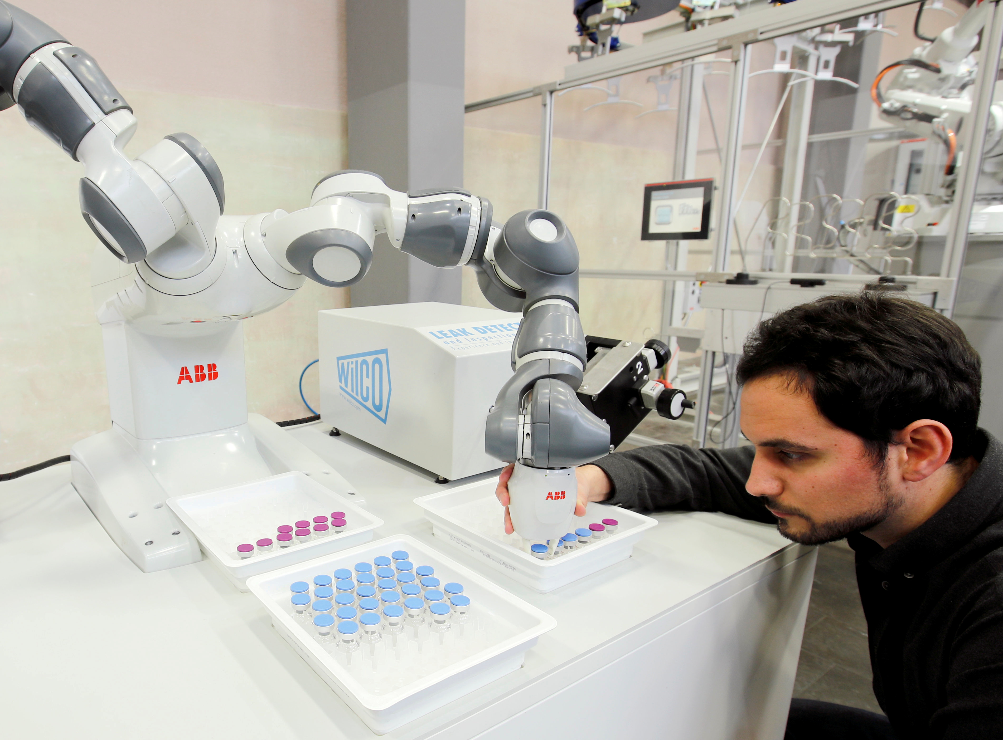 Engineer Trilla of ABB adjusts an arm of a YuMi - IRB14000 robot in Baden