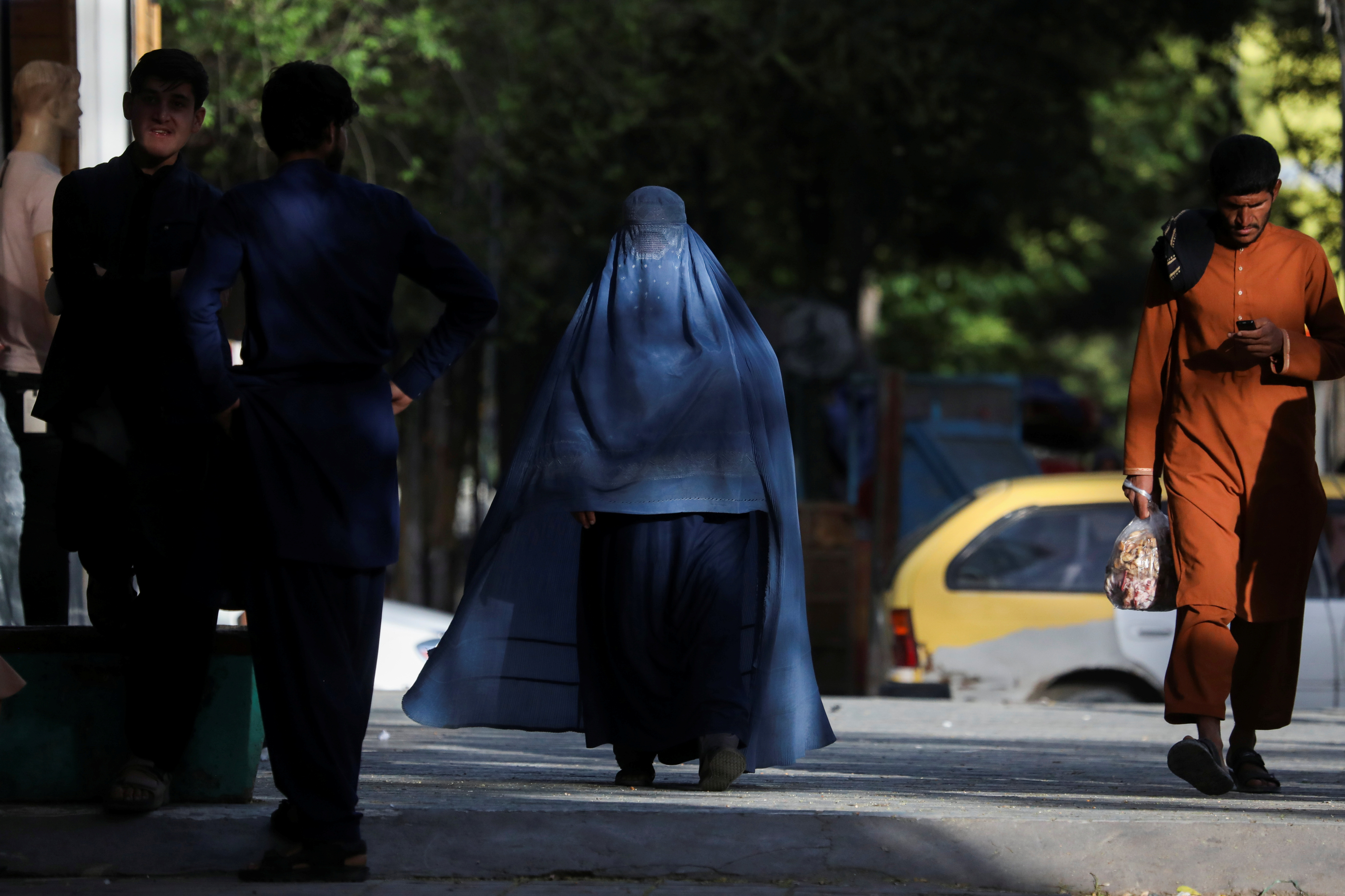 An Afghan woman walks on a street in Kabul