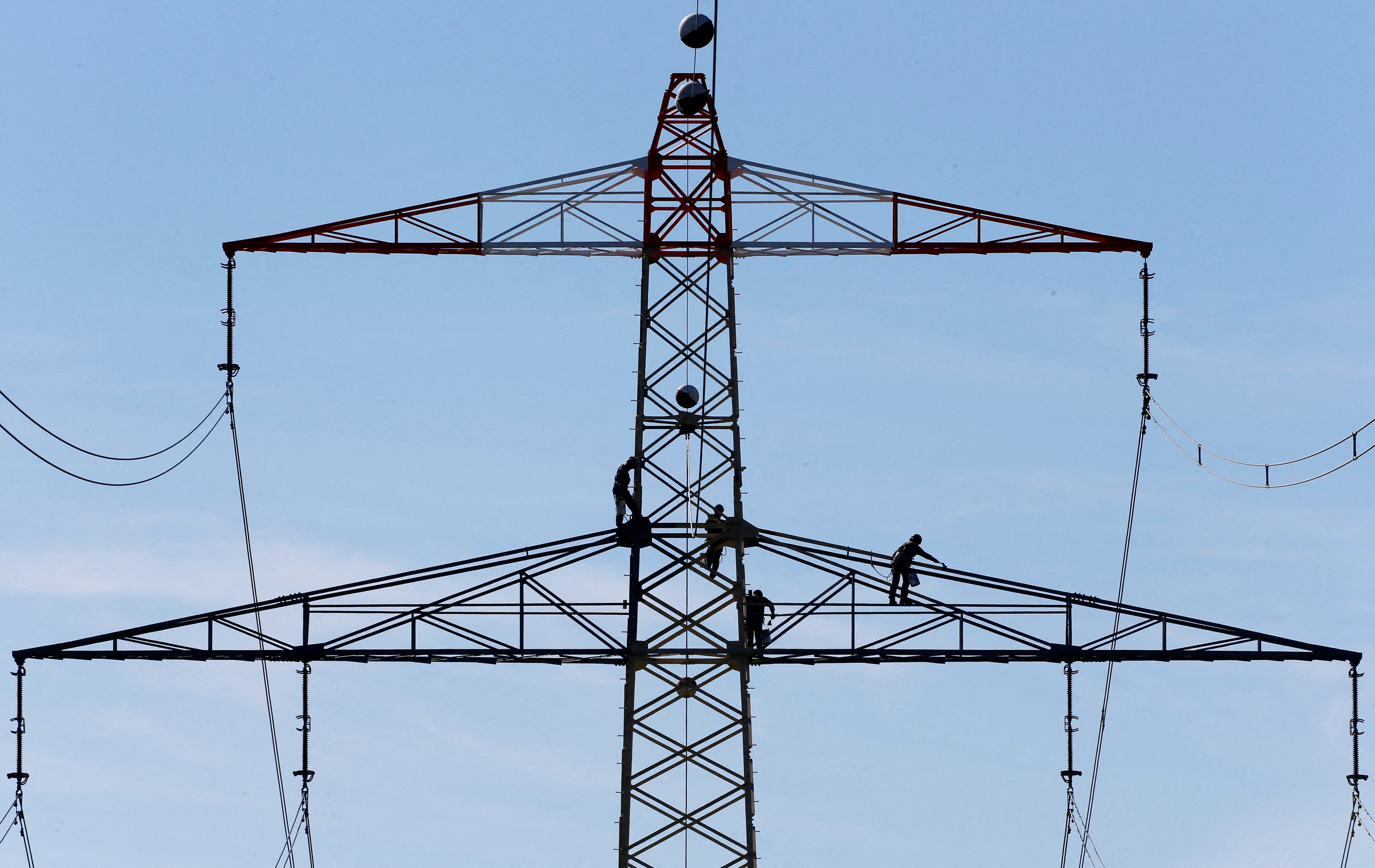 Workers renovate an electricity pylon near Gilching south of Munich