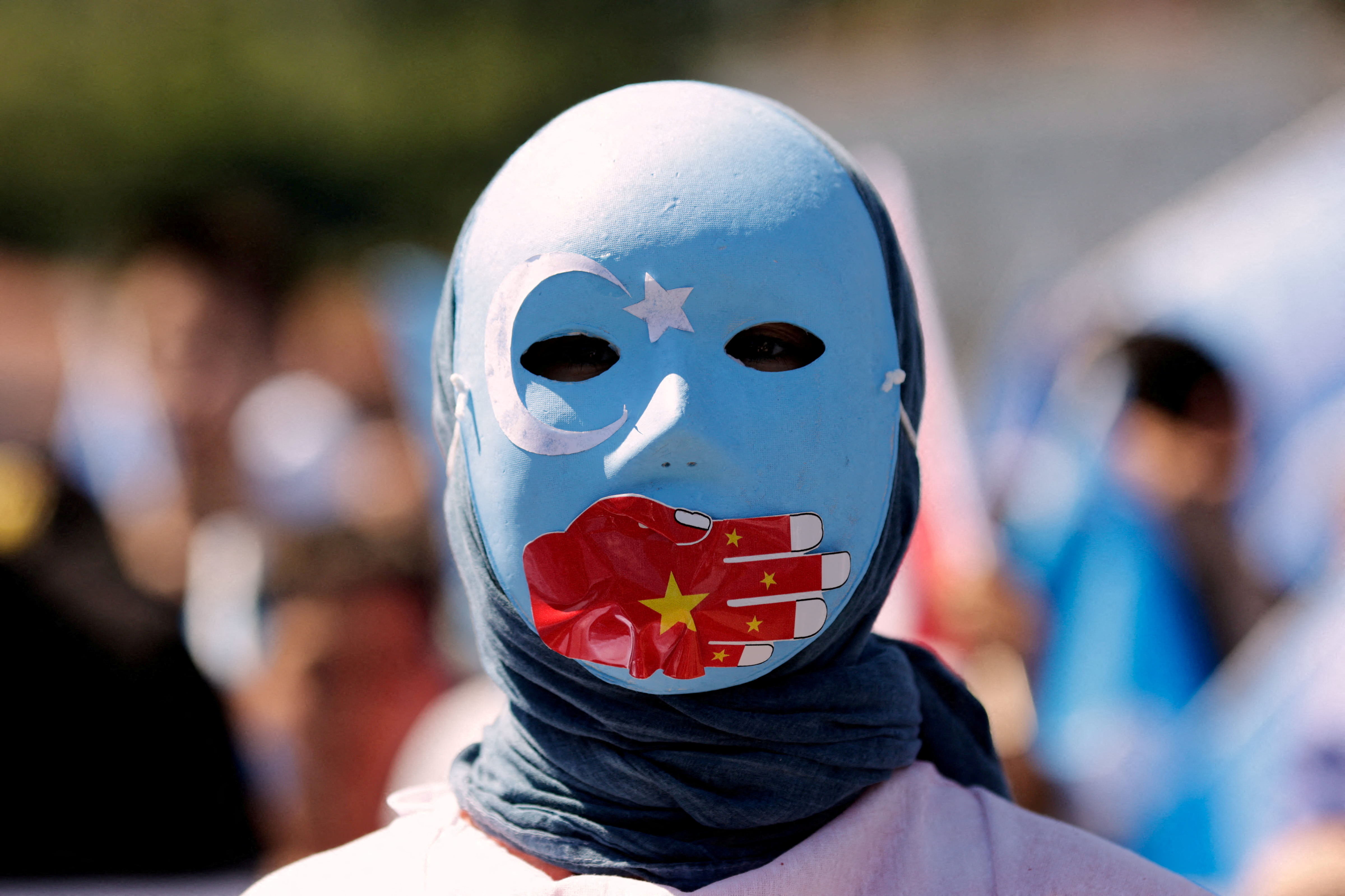 An ethnic Uyghur demonstrator wearing a mask takes part in a protest against China near the Chinese consulate in Istanbul