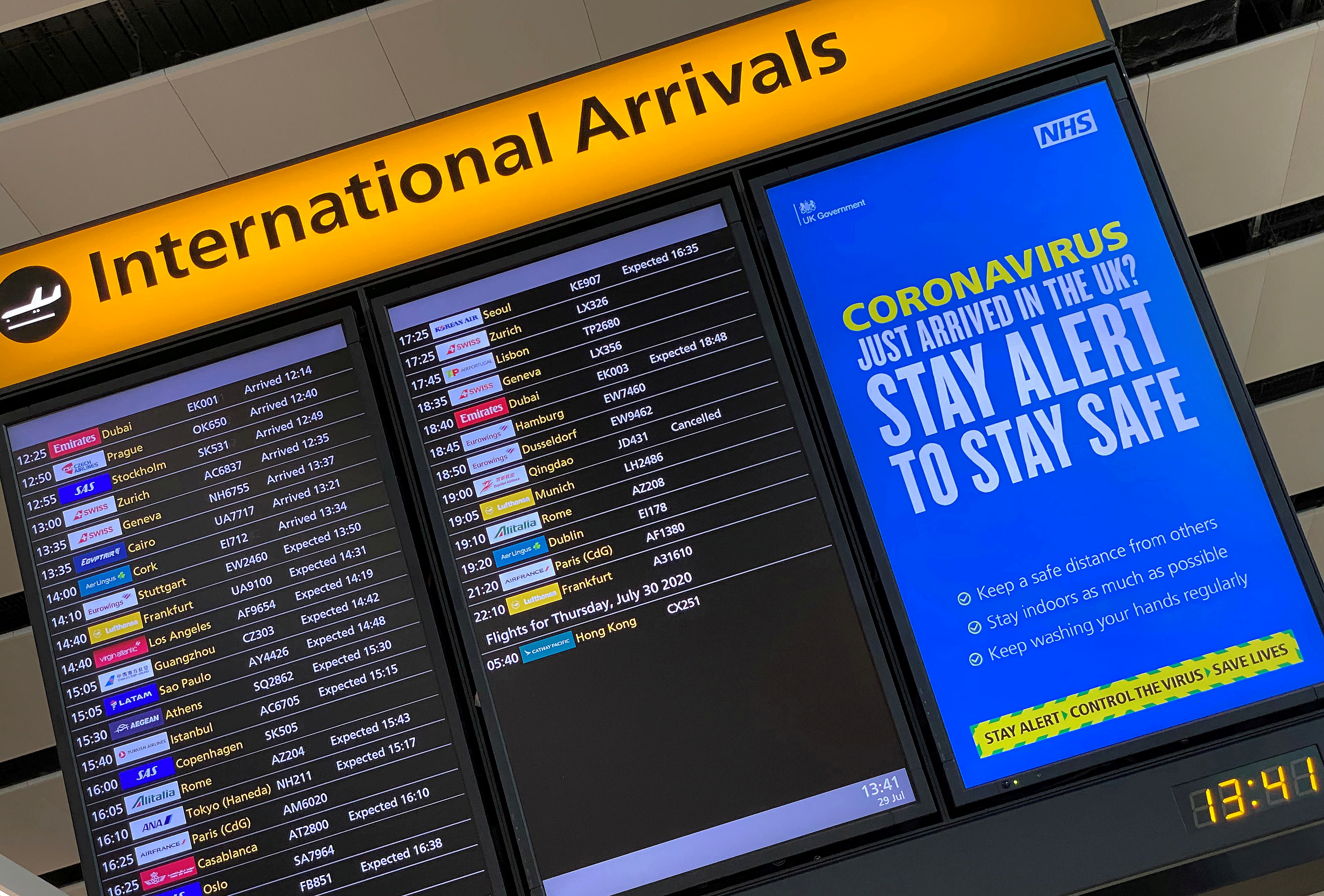 A public health campaign message is displayed on an arrivals information board at Heathrow Airport, following the outbreak of the coronavirus disease (COVID-19), London, Britain