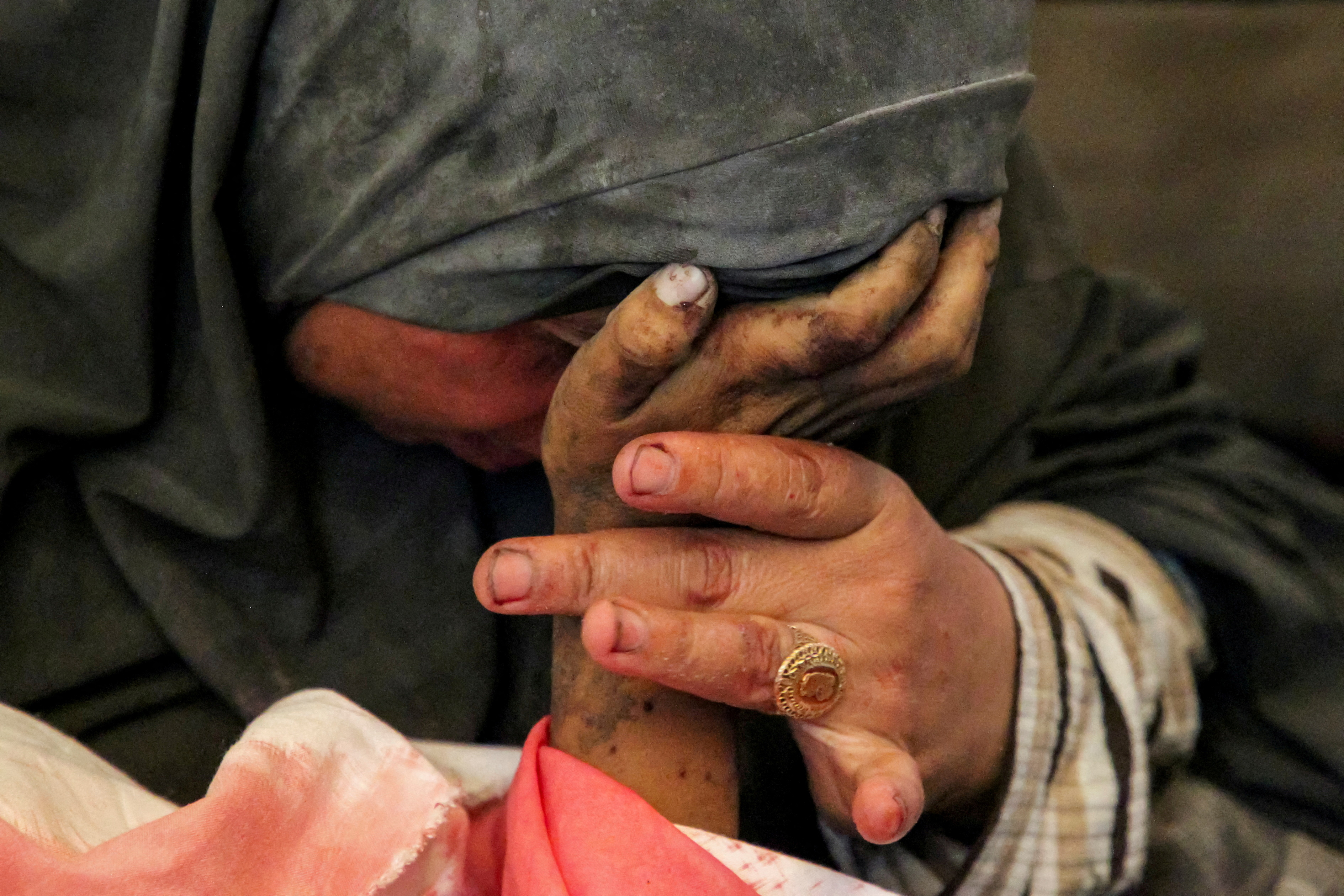 Palestinian woman Buthayna Abu Jazar reacts as she holds the hand of her son Hazma, in Rafah