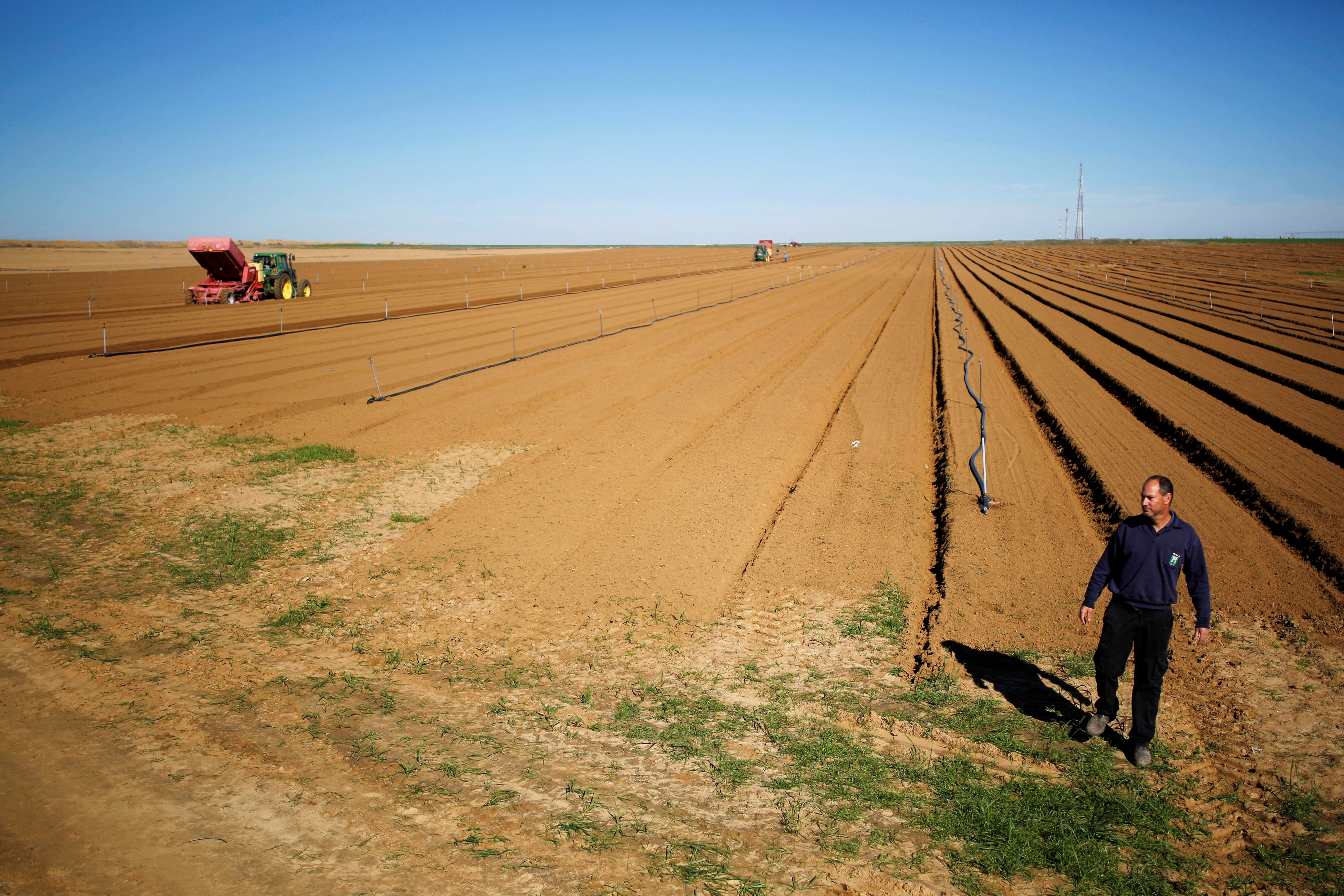 Israeli farmer Elad Katzir walks in his field near the border with the southern Gaza Strip, in Nir Oz