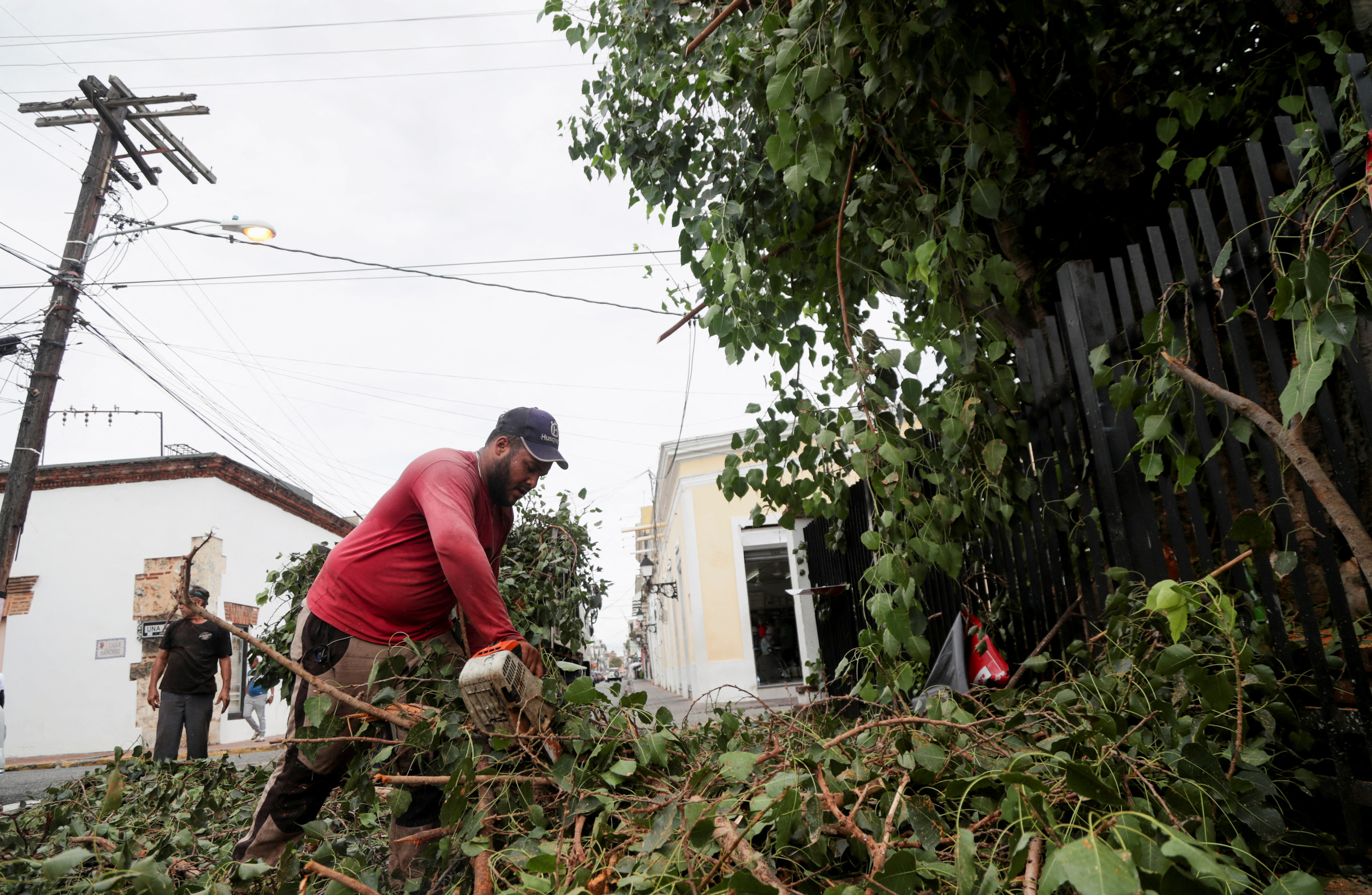 Workers cut tree branches in preparation for Hurricane Fiona, in Santo Domingo