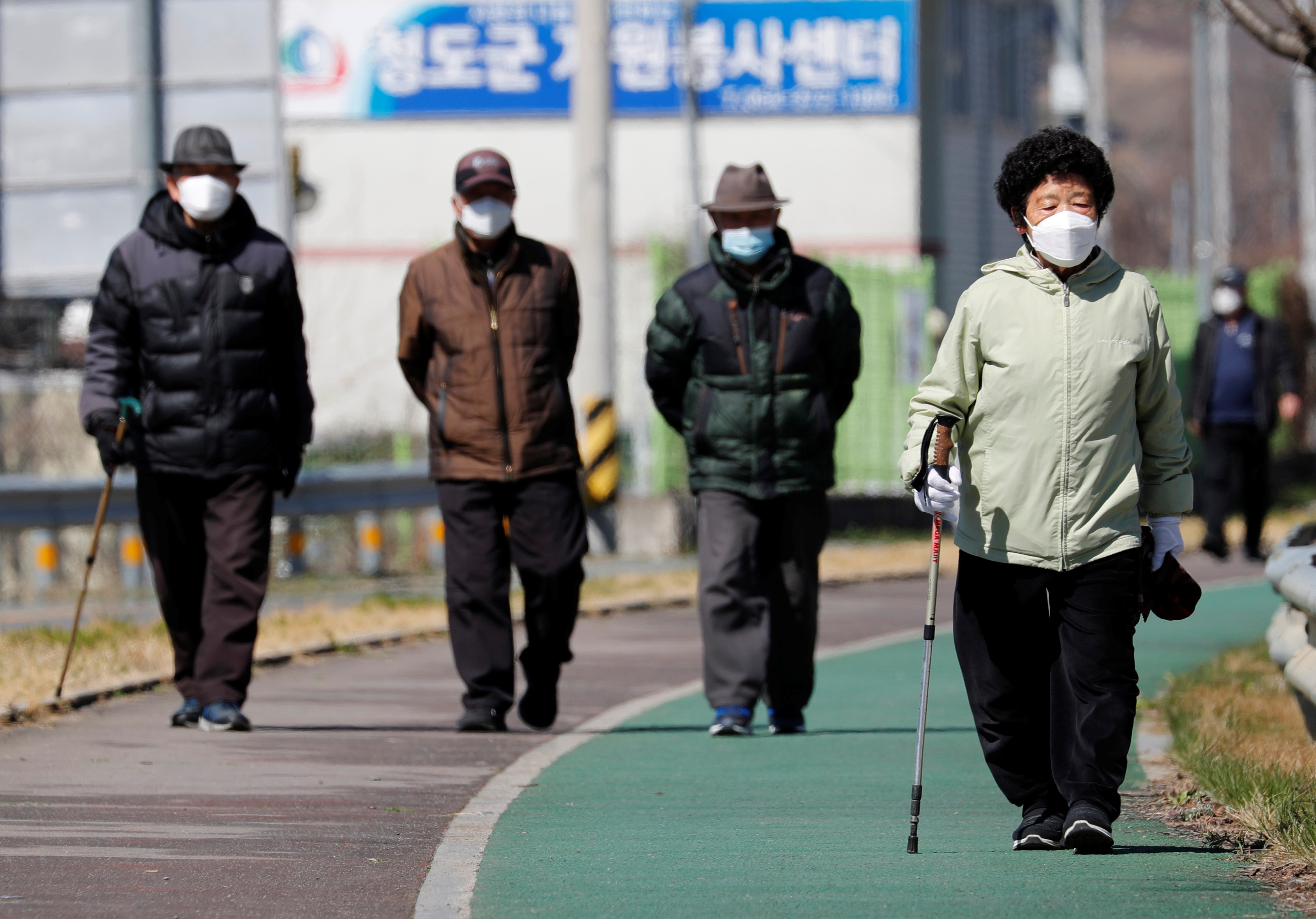 People wearing protective face masks following an outbreak of coronavirus disease (COVID-19), follow a trail in Cheongdo county