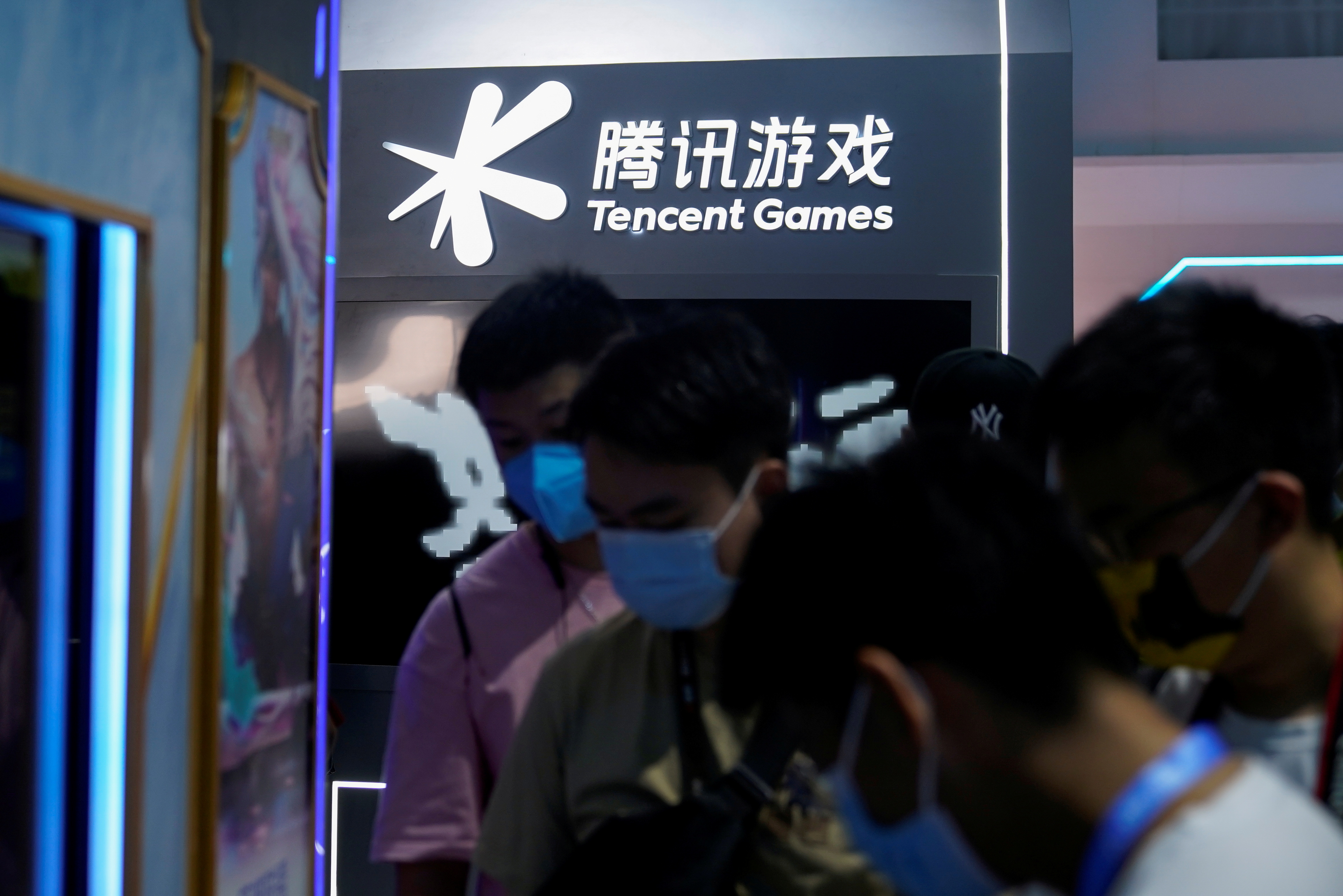Visitors are seen at the Tencent Games booth during the China Digital Entertainment Expo and Conference, also known as ChinaJoy, in Shanghai