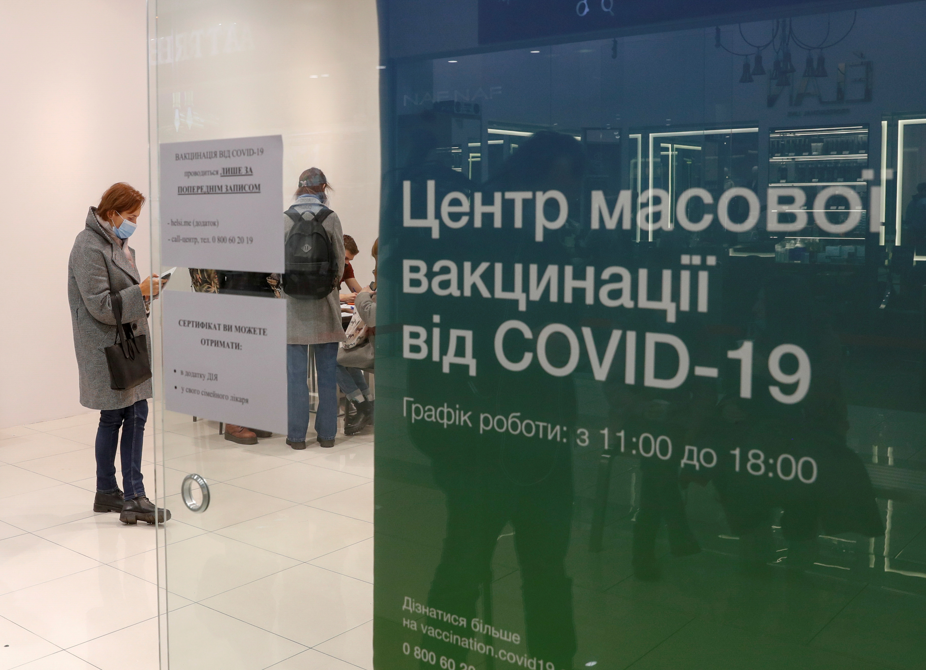 People wait to receive an injection of vaccine against the coronavirus disease (COVID-19) at a vaccination centre in a shopping mall in Kyiv, Ukraine October 27, 2021. Picture taken October 27, 2021. REUTERS/Valentyn Ogirenko