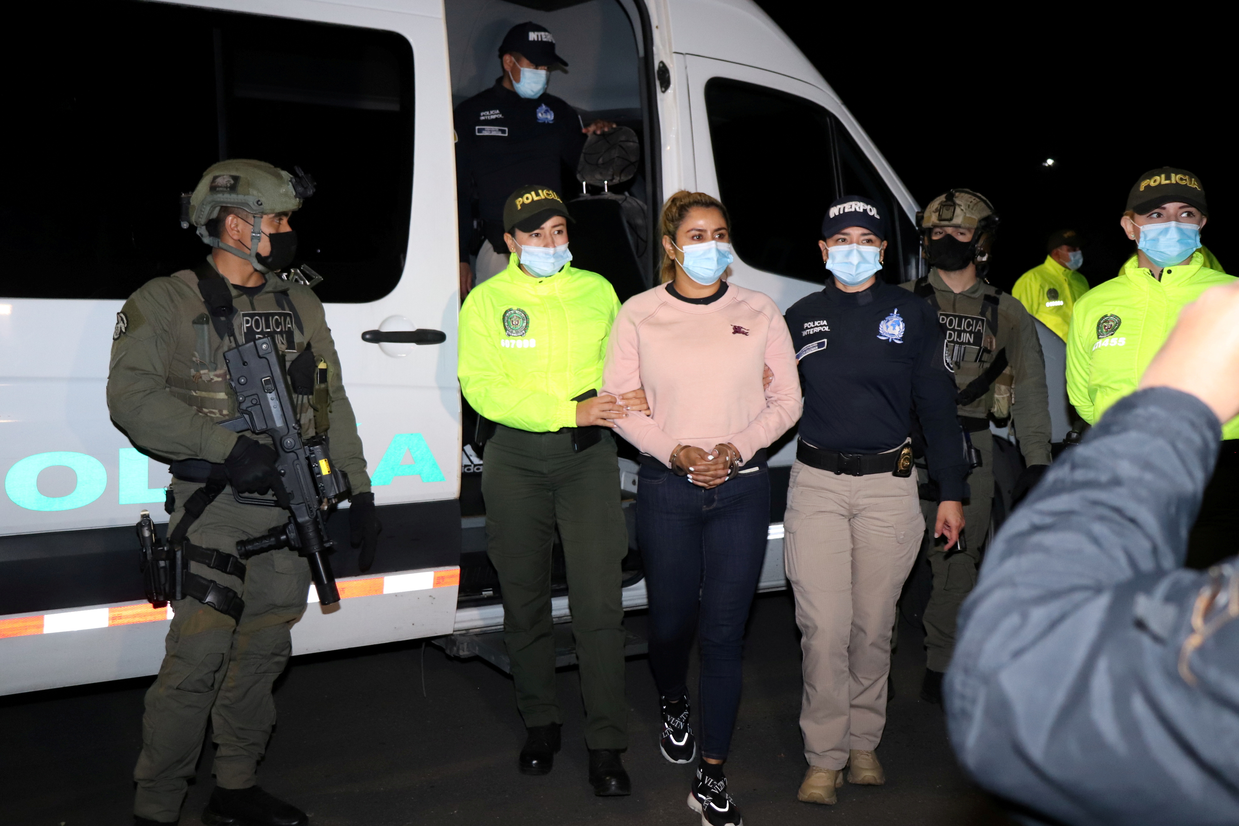 Colombian National Police officers escort Nini Johana Usuga, alias 'La Negra', sister of 'Otoniel', top leader of the organized armed group Clan del Golfo, after her arrest in Sabaneta, Colombia March 18, 2021. Colombian National Police/Handout via REUTERS 