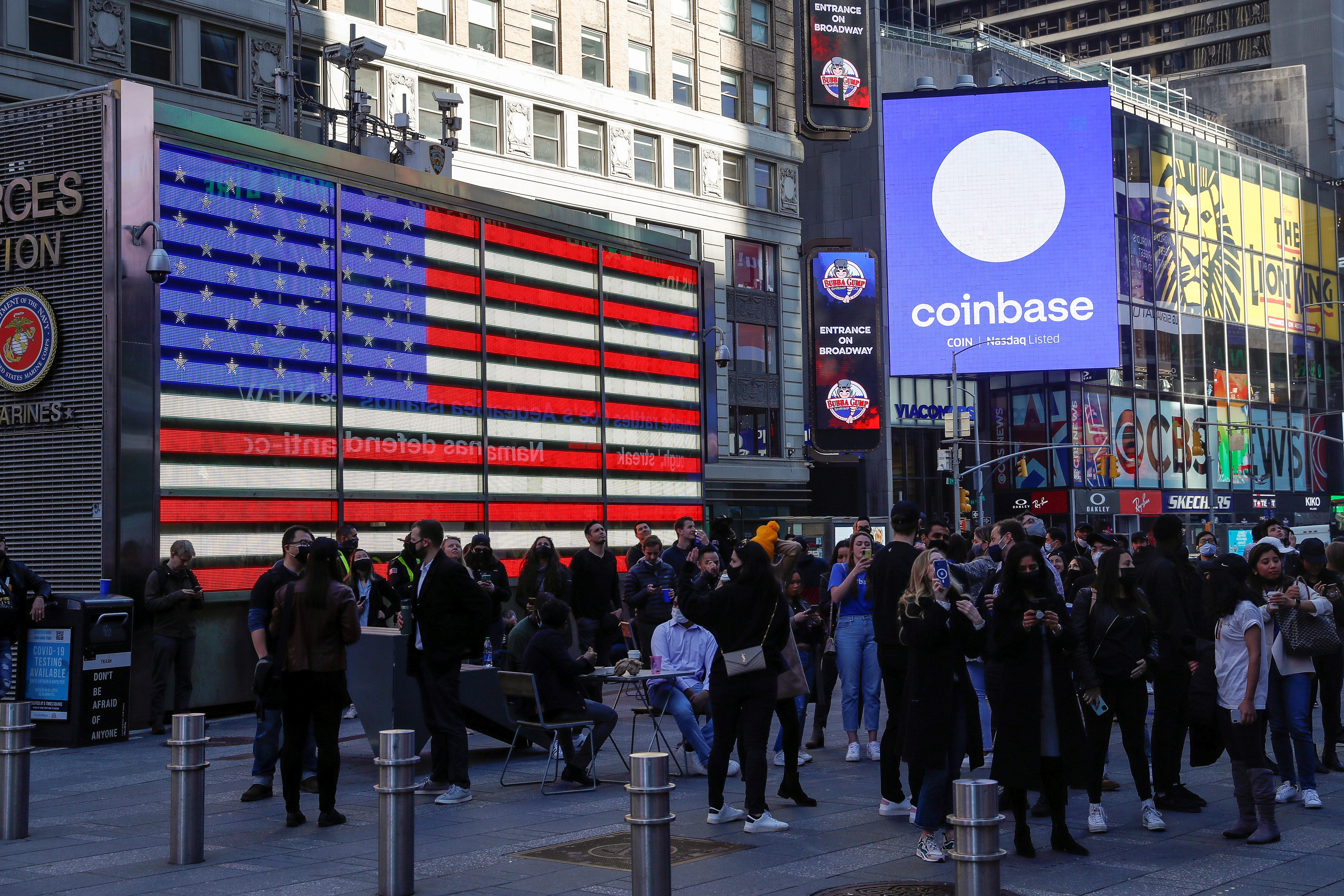 Employees of Coinbase Global Inc, the biggest U.S. cryptocurrency exchange, watch as their listing is displayed on the Nasdaq MarketSite jumbotron at Times Square in New York