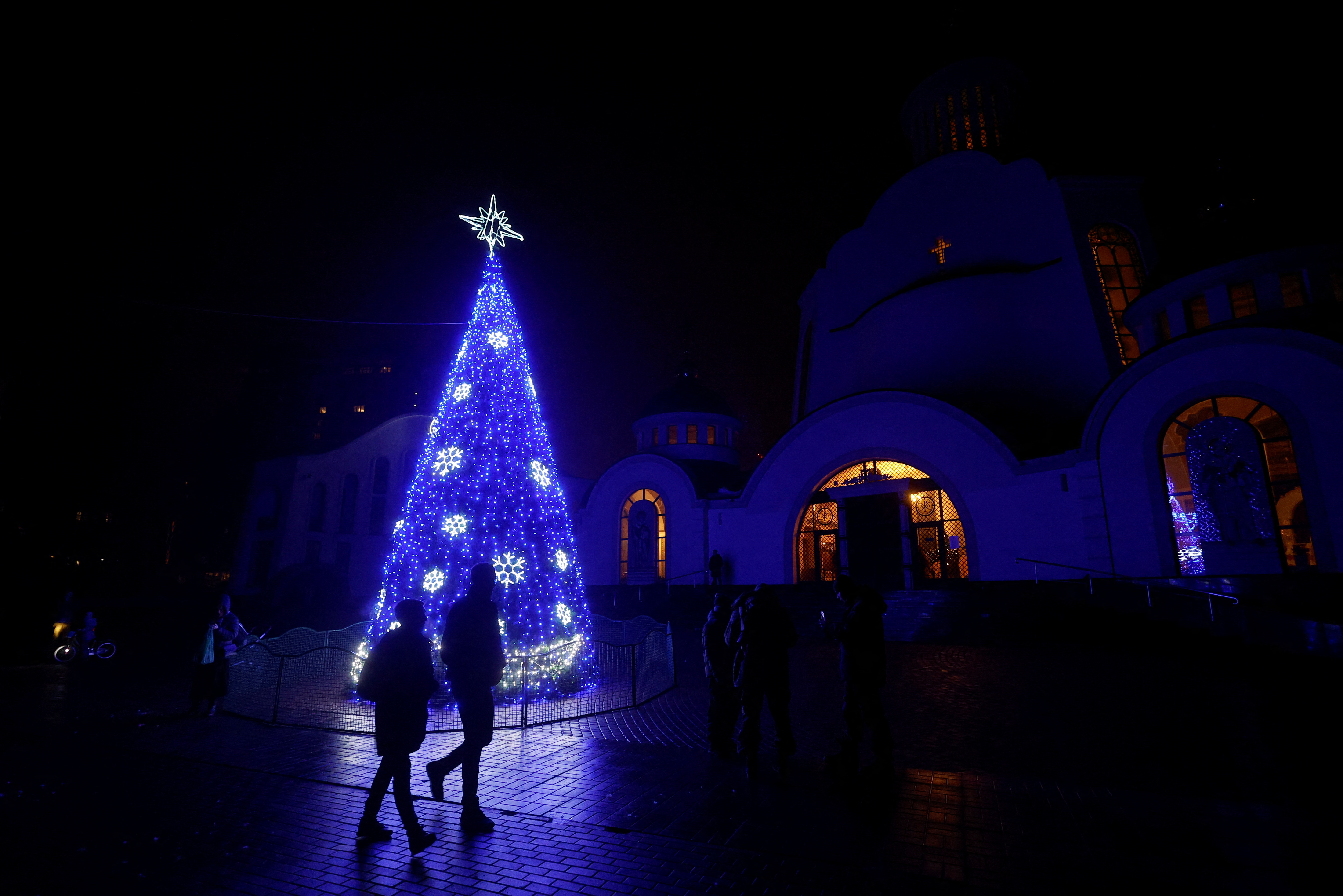 Christmas tree is seen in front of an Orthodox cathedral during a service on the eve of Christmas in Kyiv