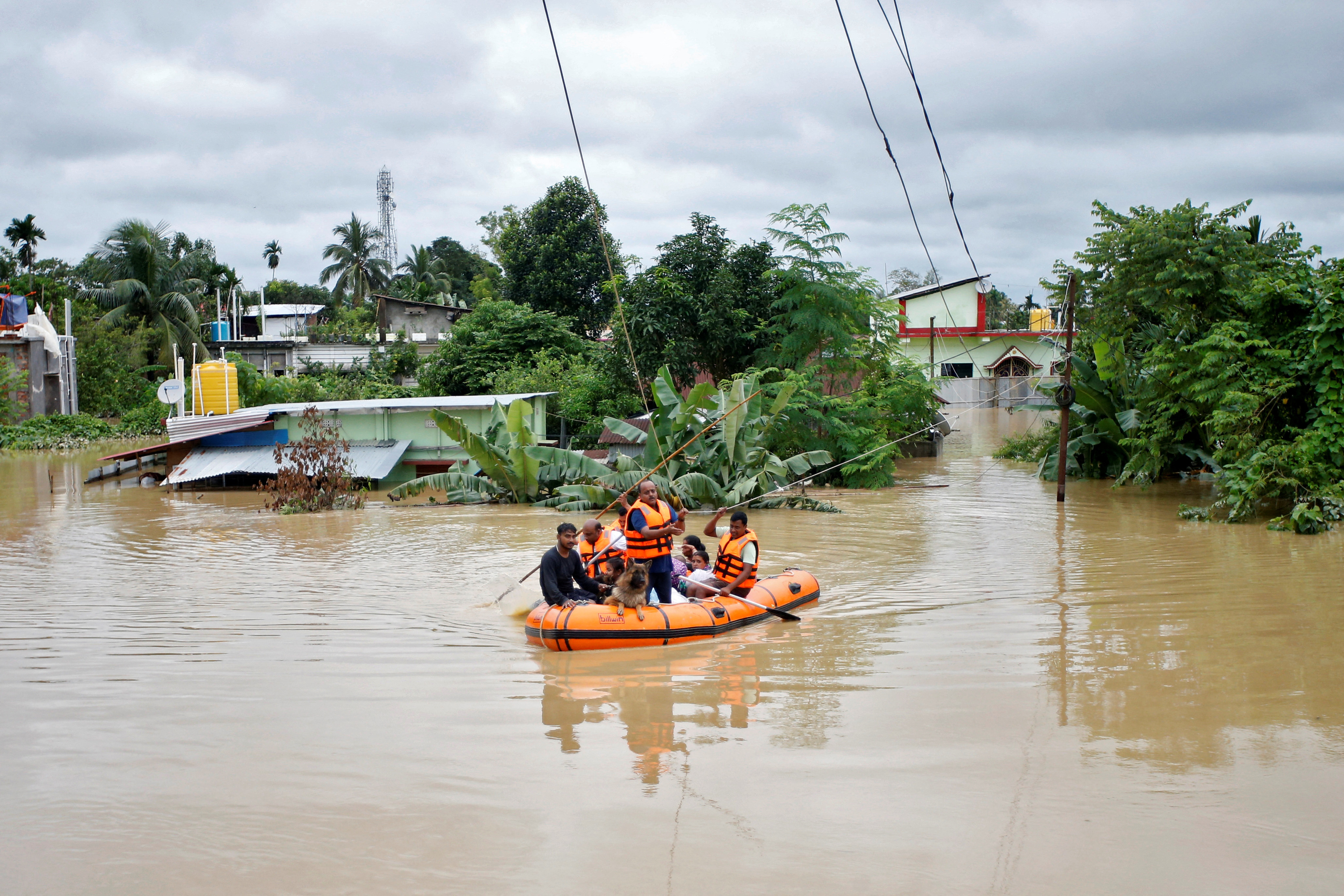 Rescuers from Tripura Disaster Management Authority evacuate flood-affected people to a safer place, on the outskirts of Agartala