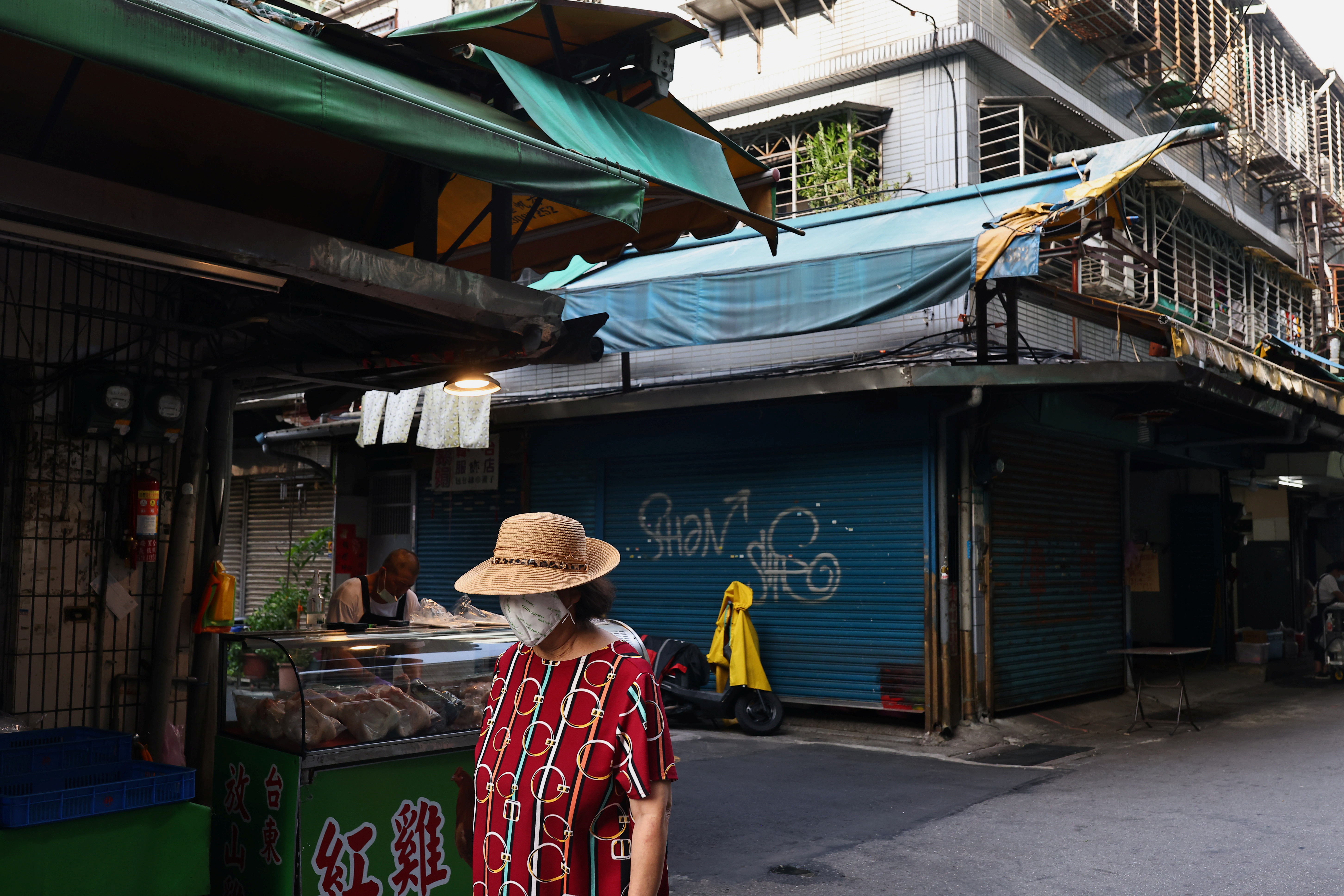 A woman wearing a protective face mask shops at a market amid the coronavirus disease