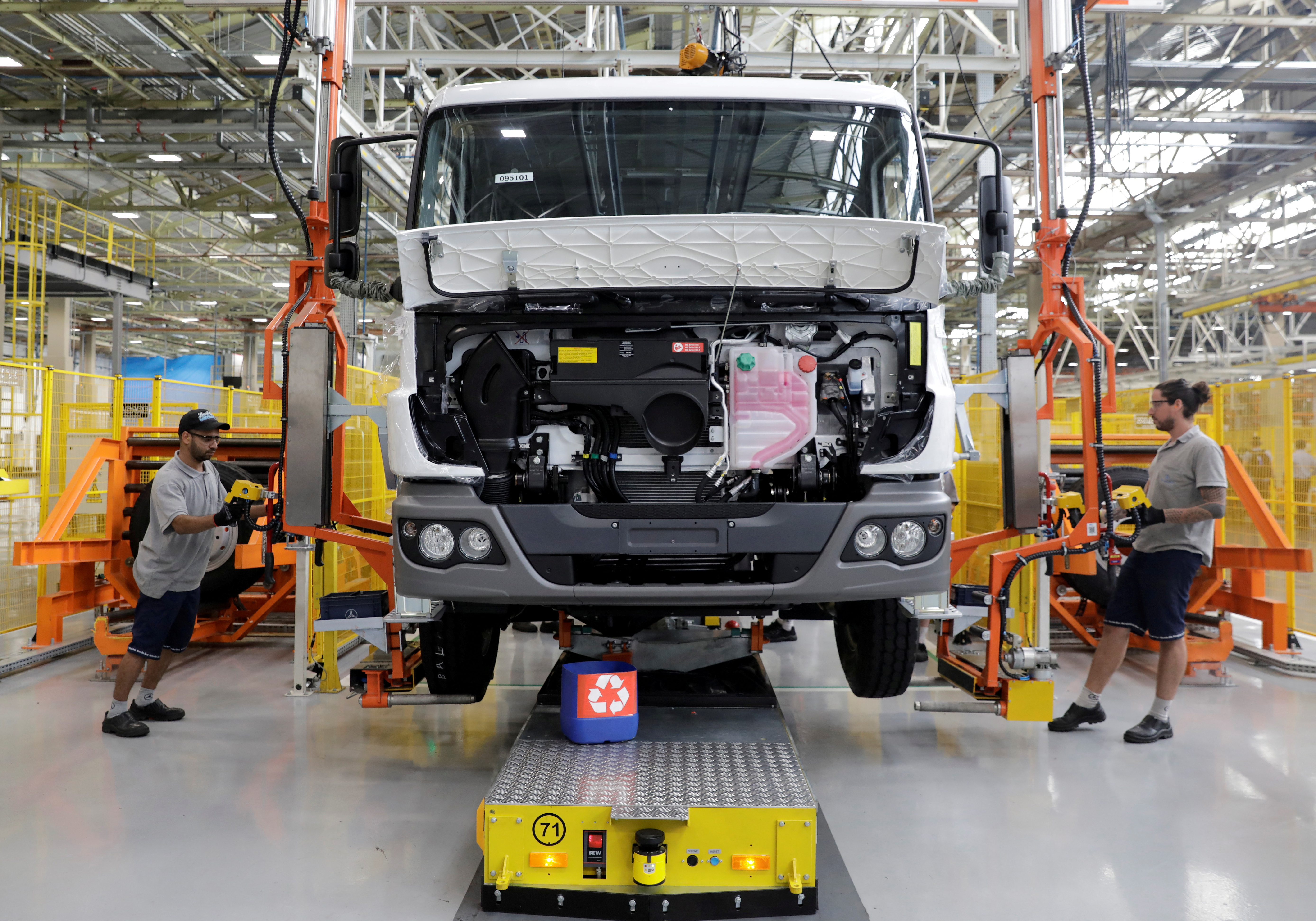 Employees work on the new assembly line to build trucks at Mercedes Benz's trucks and buses manufacturing plant in Sao Bernardo do Campo