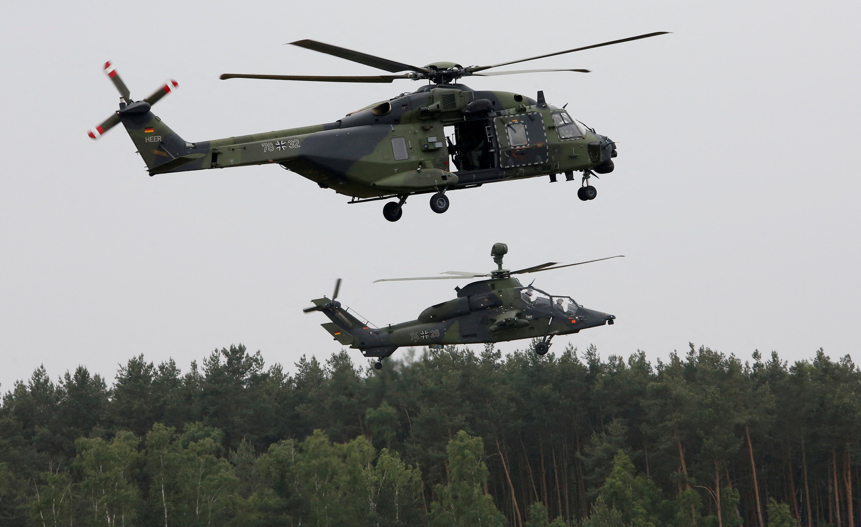 A German Bundeswehr armed forces NH 90 helicopter and a Tiger attack helicopter are seen during a drill at Holzdorf Air Base