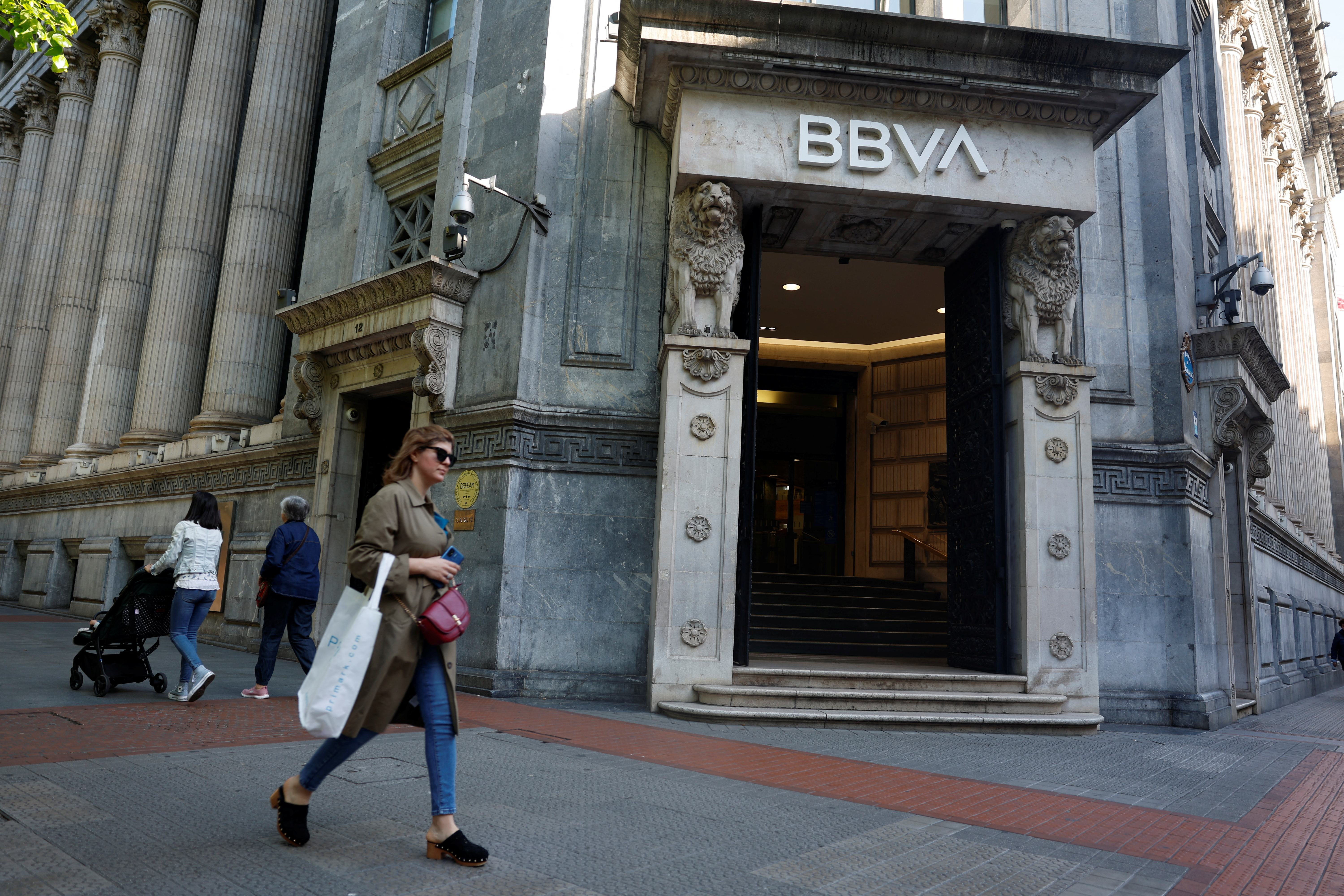 A woman walks past a branch of Spain's BBVA bank in the Gran Via of Bilbao