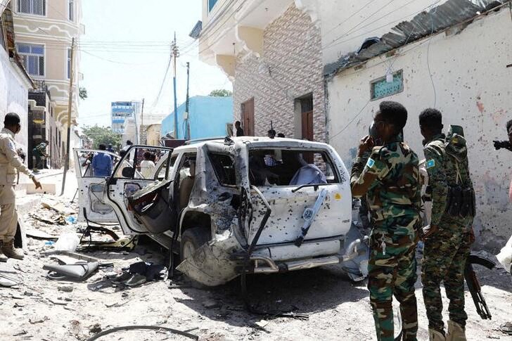 Somali security look at the wreckage of a vehicle at the scene of an explosion Mogadishu