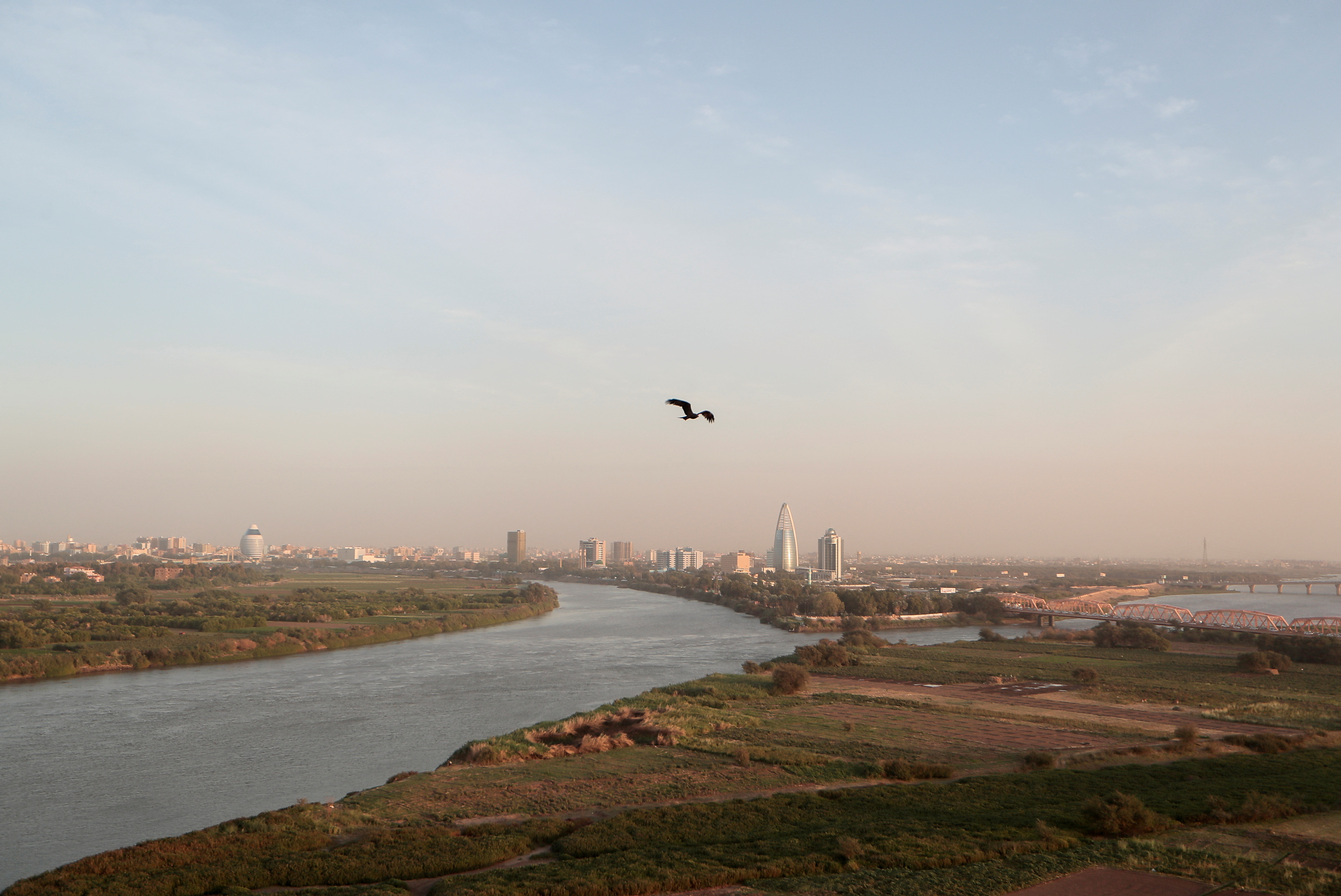 A bird flies over the convergence between the White Nile river and Blue Nile river in Khartoum, Sudan