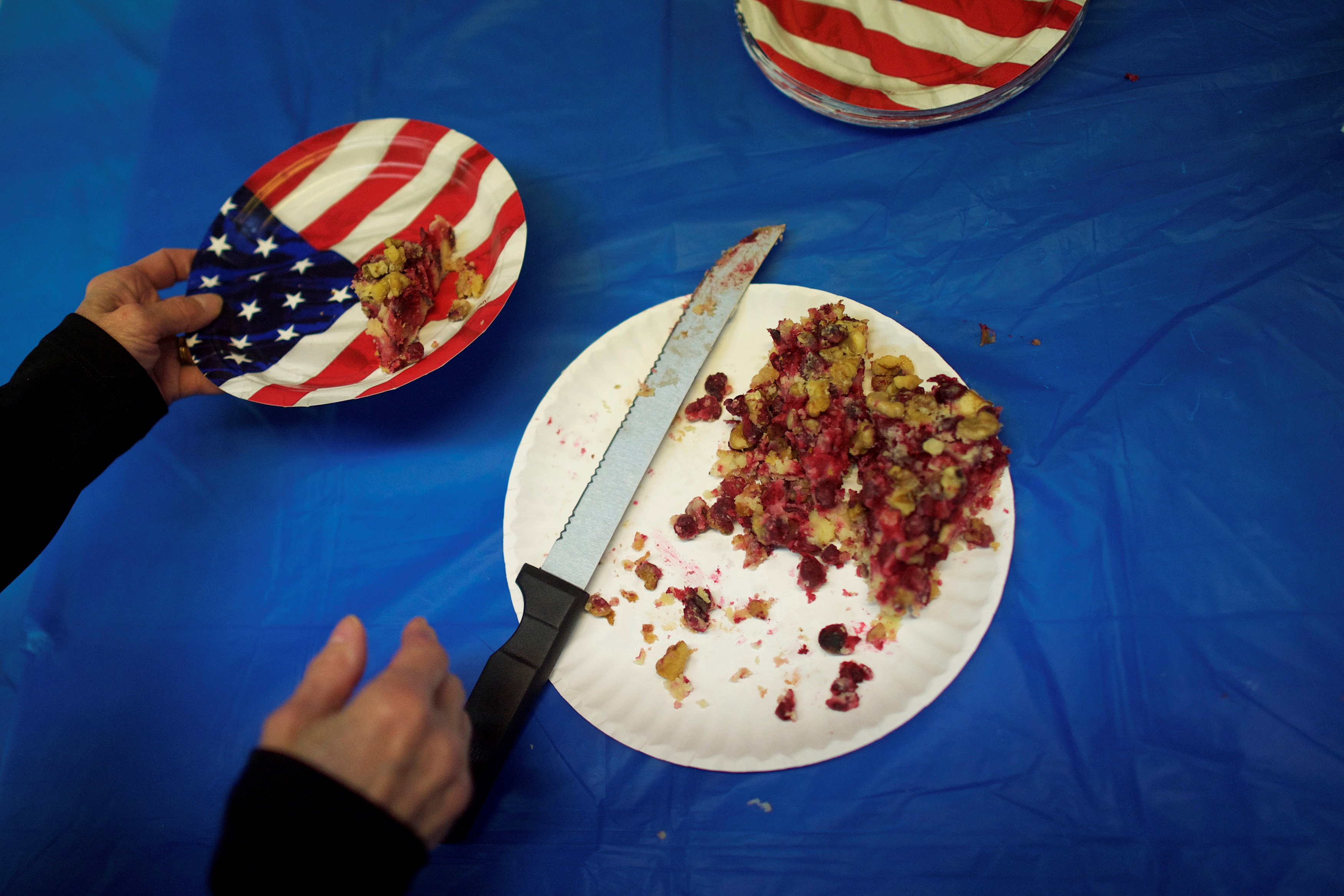 Volunteer Anne Scerbo places a piece of cranberry cake onto a U.S. flag themed paper plate during a break from phone calls at the York County Democratic Headquarters in York, Pennsylvania, November 4, 2014.  REUTERS/Mark Makela