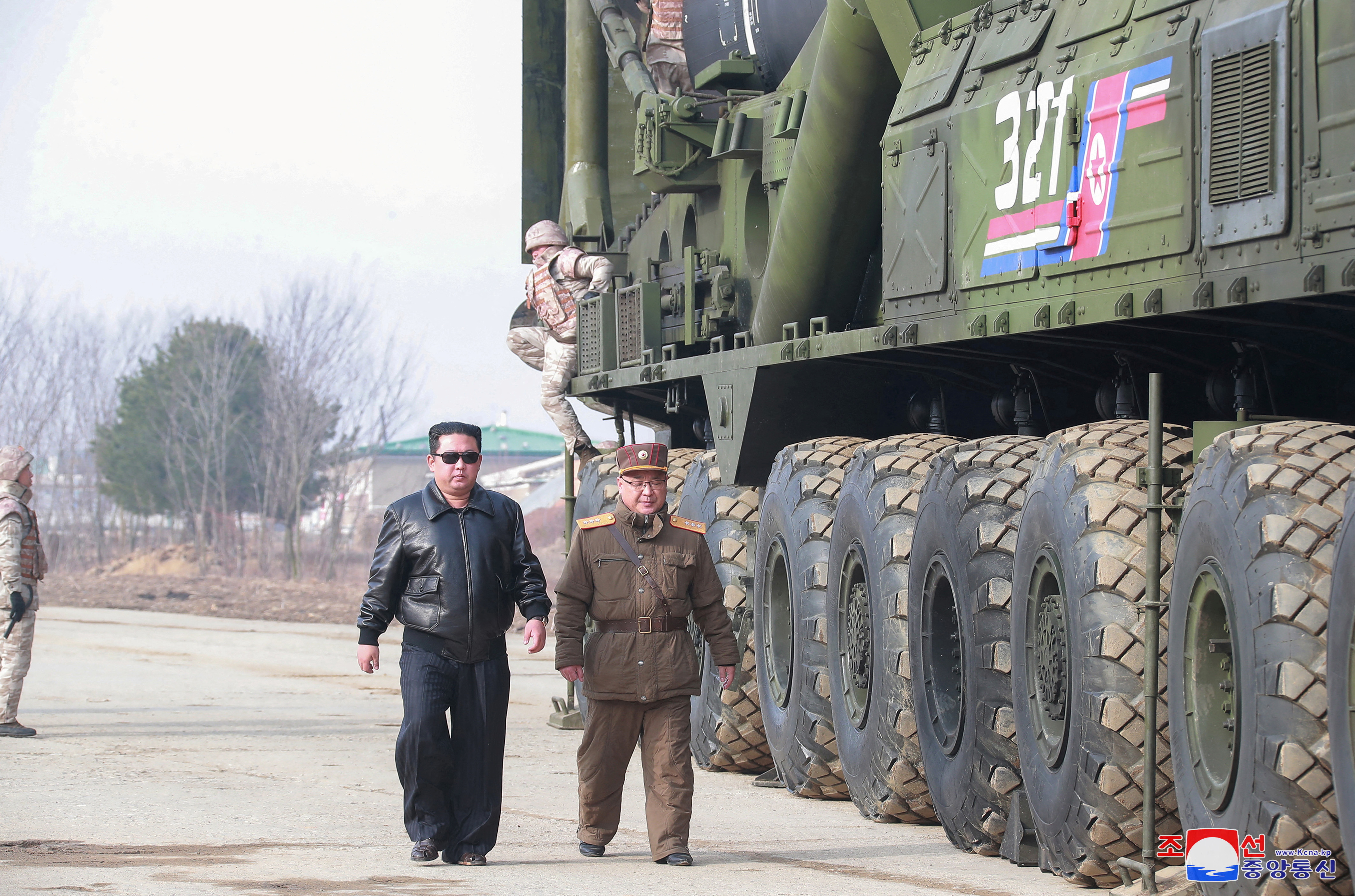 North Korean leader Kim Jong Un walks next to what state media reports is the 