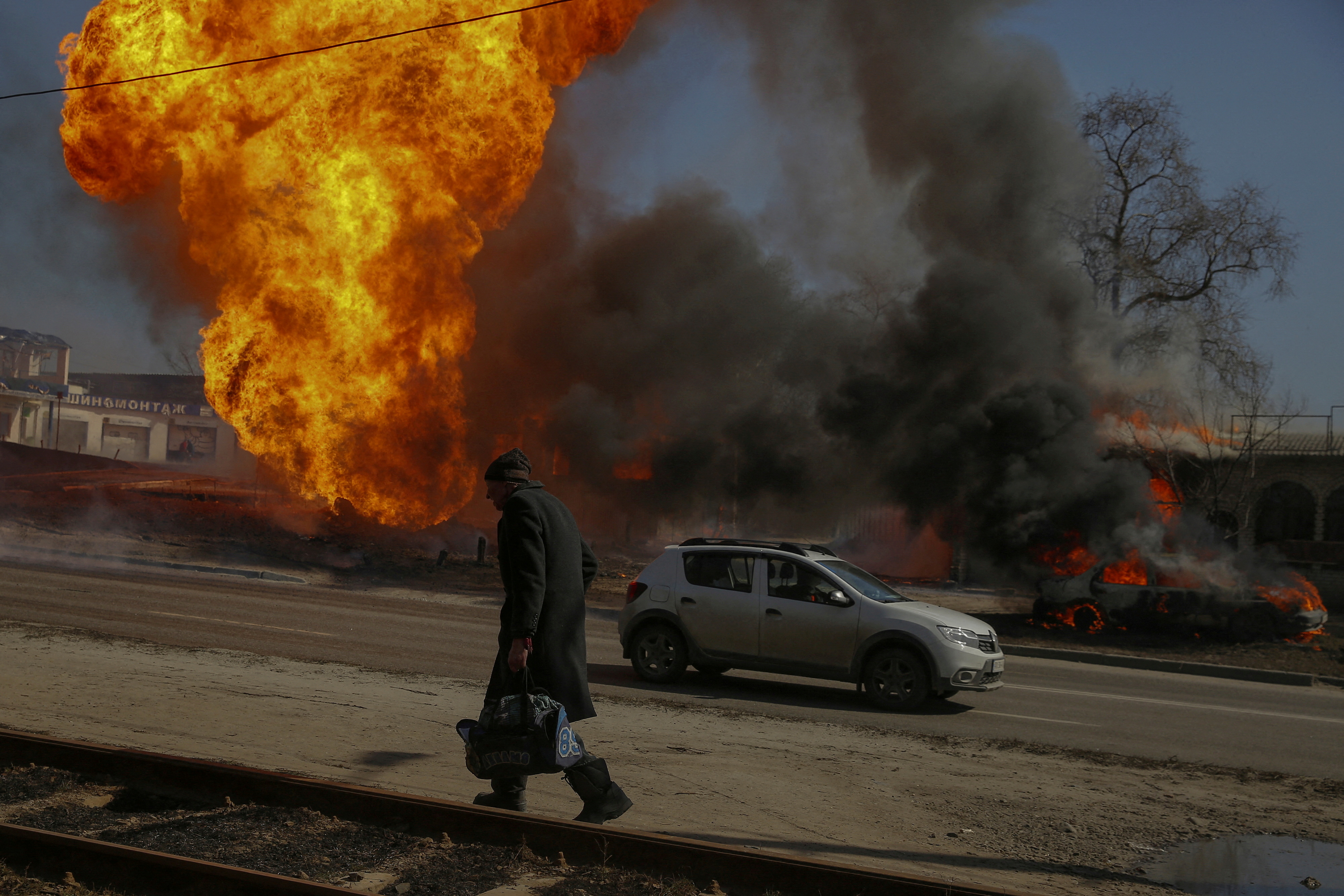 A man walks past a fire after a shelling in Kharkiv