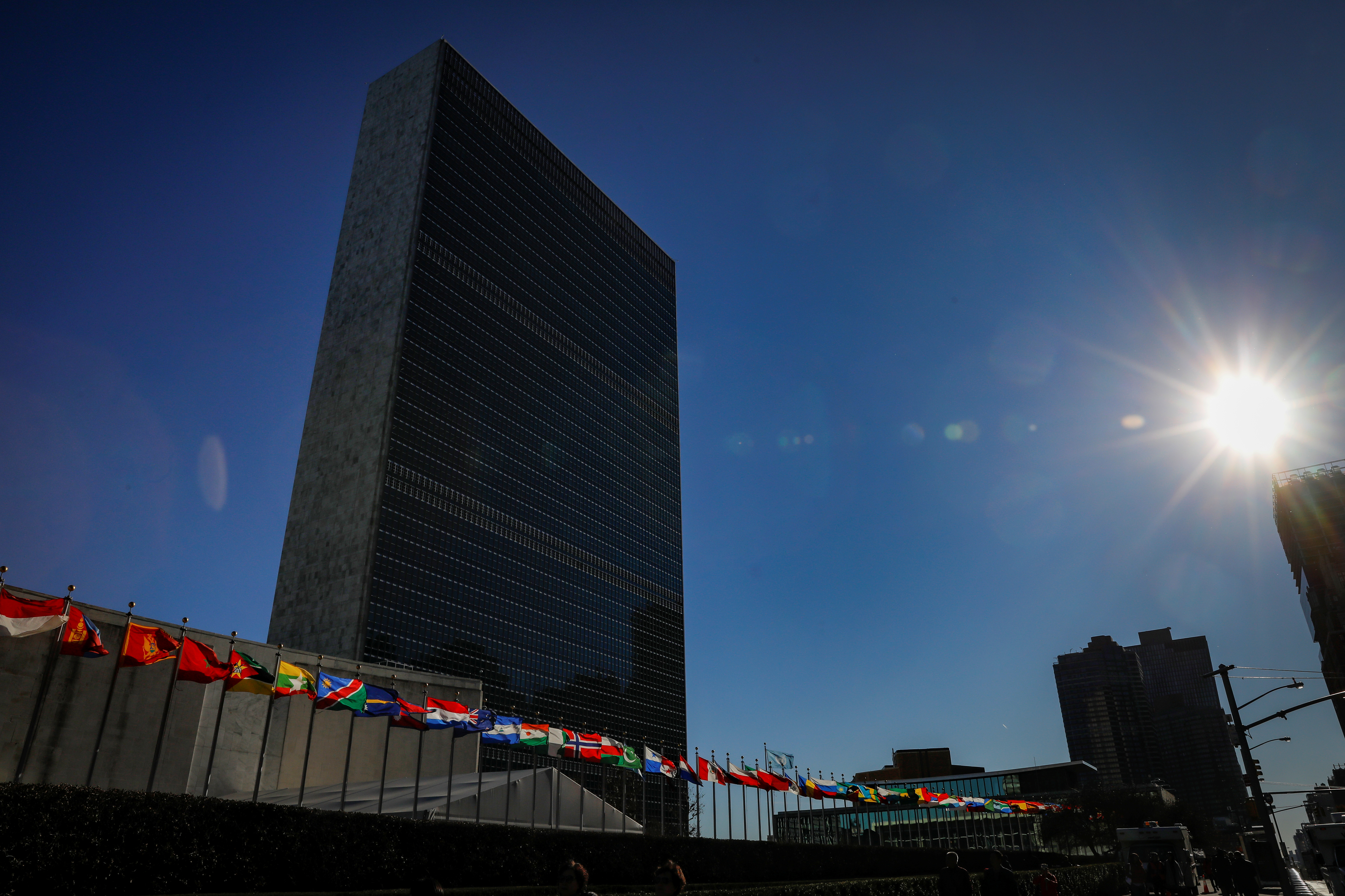 International flags fly in front of The United Nations Headquarters building in New York