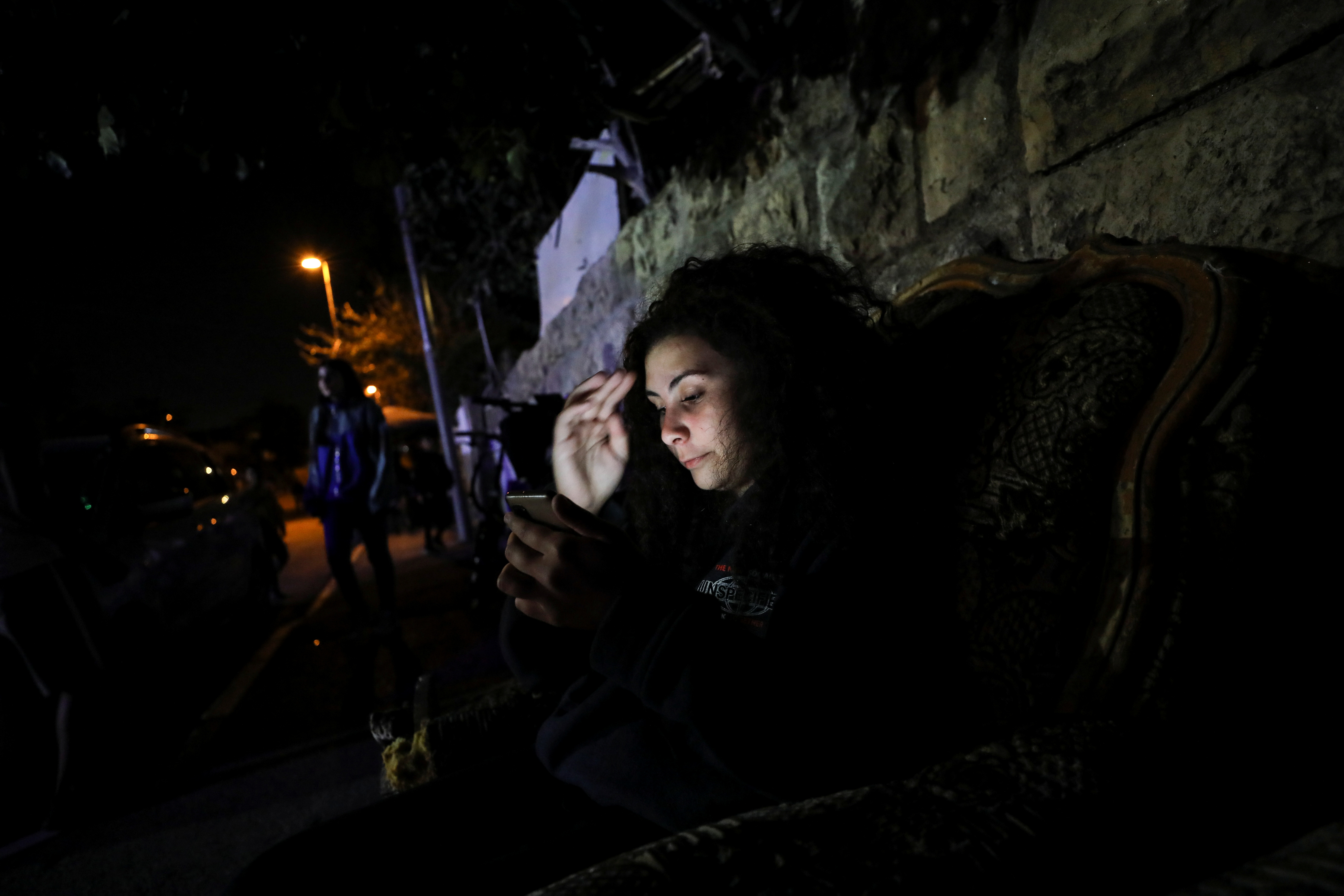 Tala, a member of the Abu Diab family, Palestinian residents of Sheikh Jarrah, uses her phone in her neighbourhood in East Jerusalem