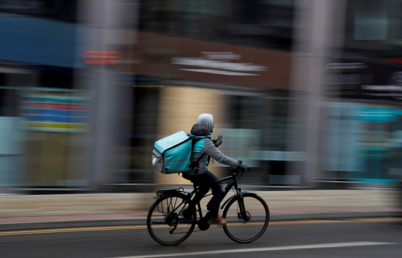 A deliveroo delivery driver cycles through the centre of Manchester, Britain, March 8, 2021. REUTERS/Phil Noble/File Photo