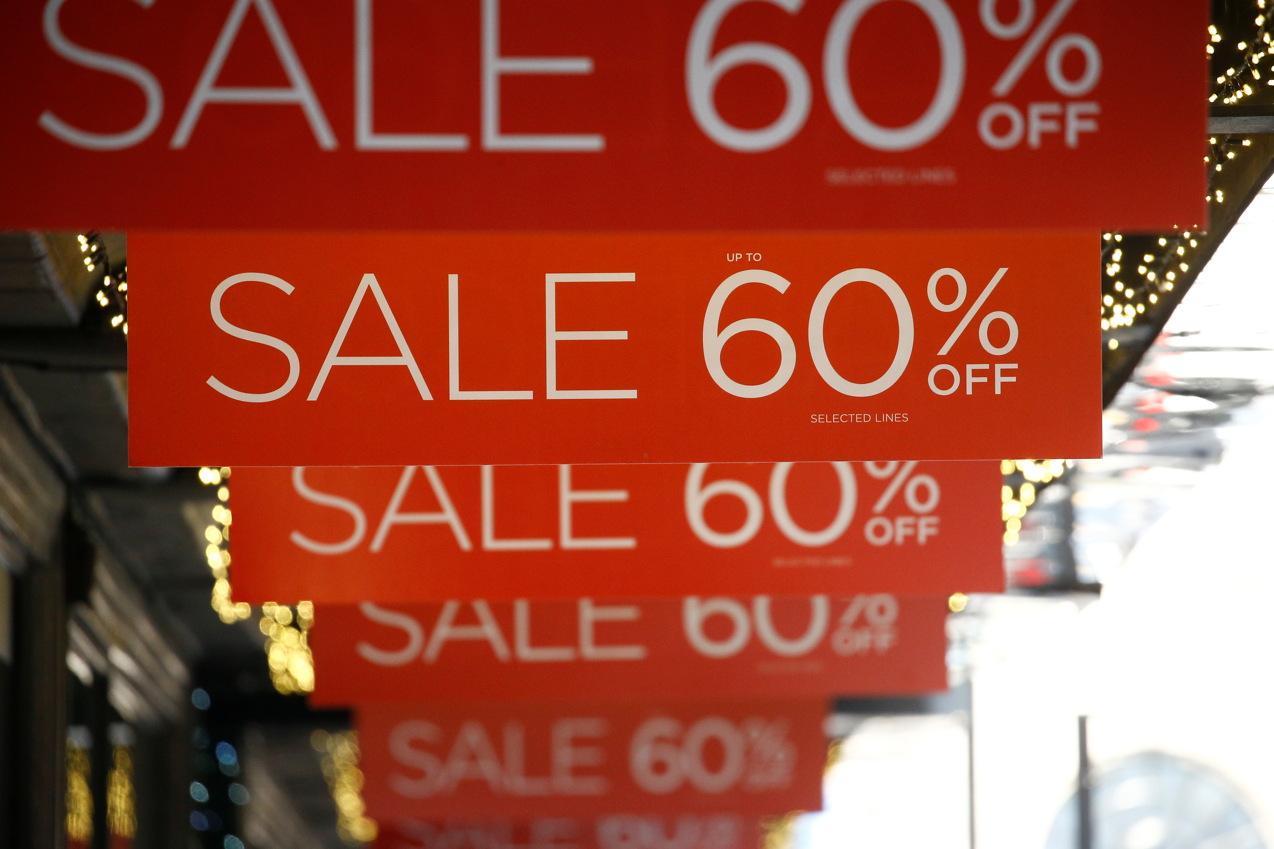 Sale signs are displayed at the front of a shop, in London