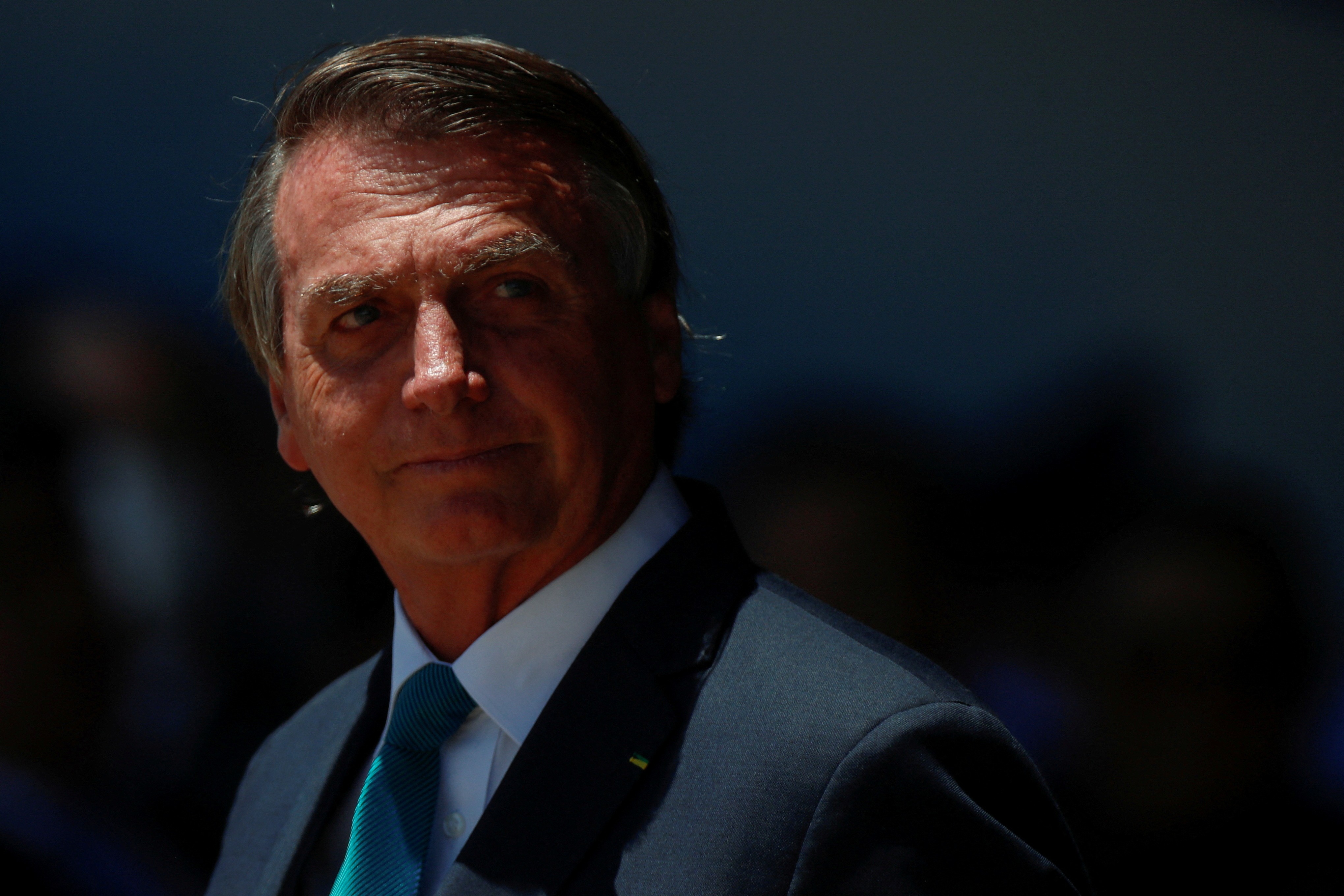 Brazil's President Jair Bolsonaro looks on during a welcoming ceremony to receive Brazilians and foreigners evacuated from Ukraine during a repatriation mission, at Brasilia Air Base, in Brasilia, Brazil