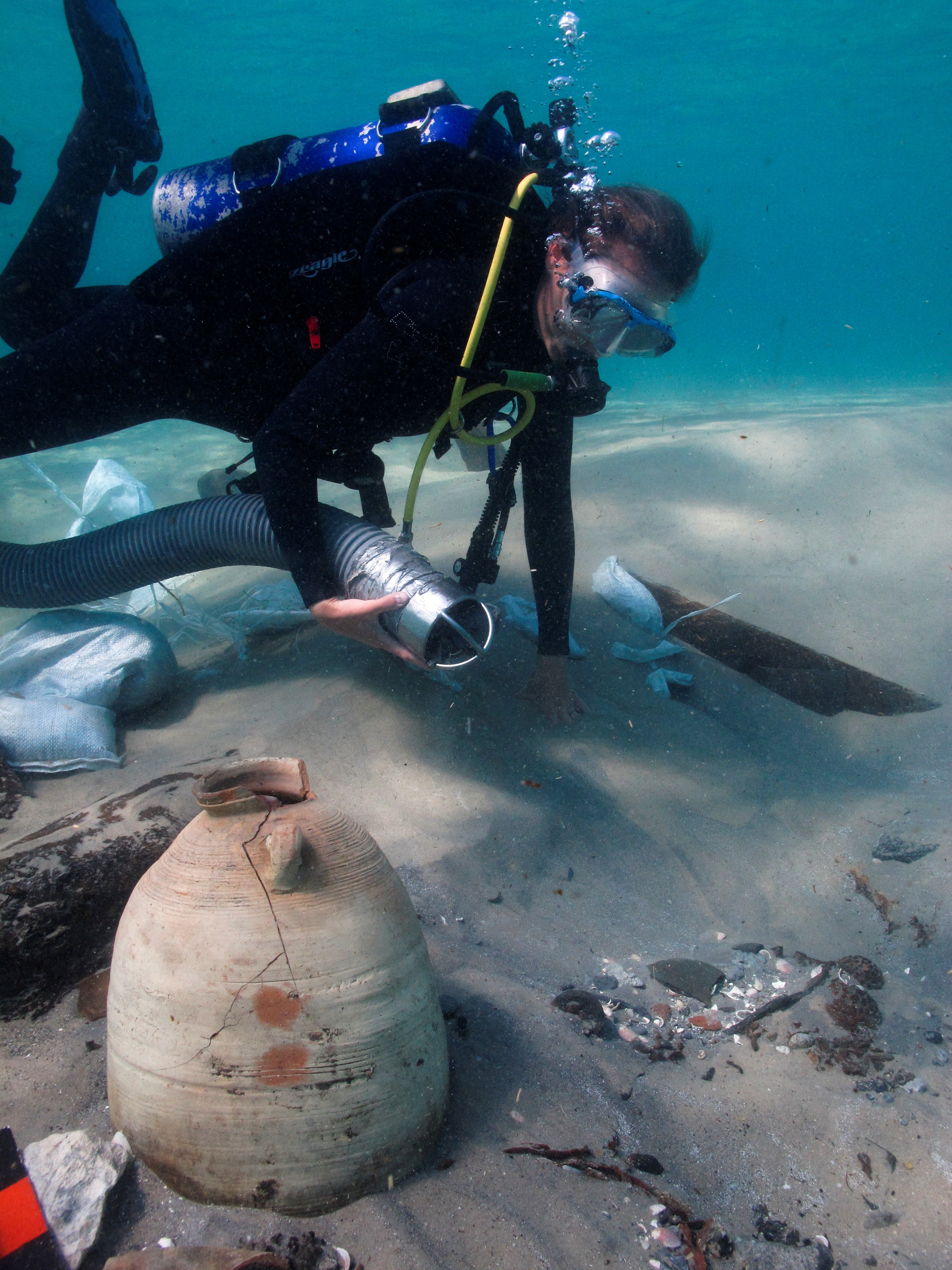 A diver excavates the remains of an ancient cargo ship, which is believed to have carried goods from all over the Mediterranean