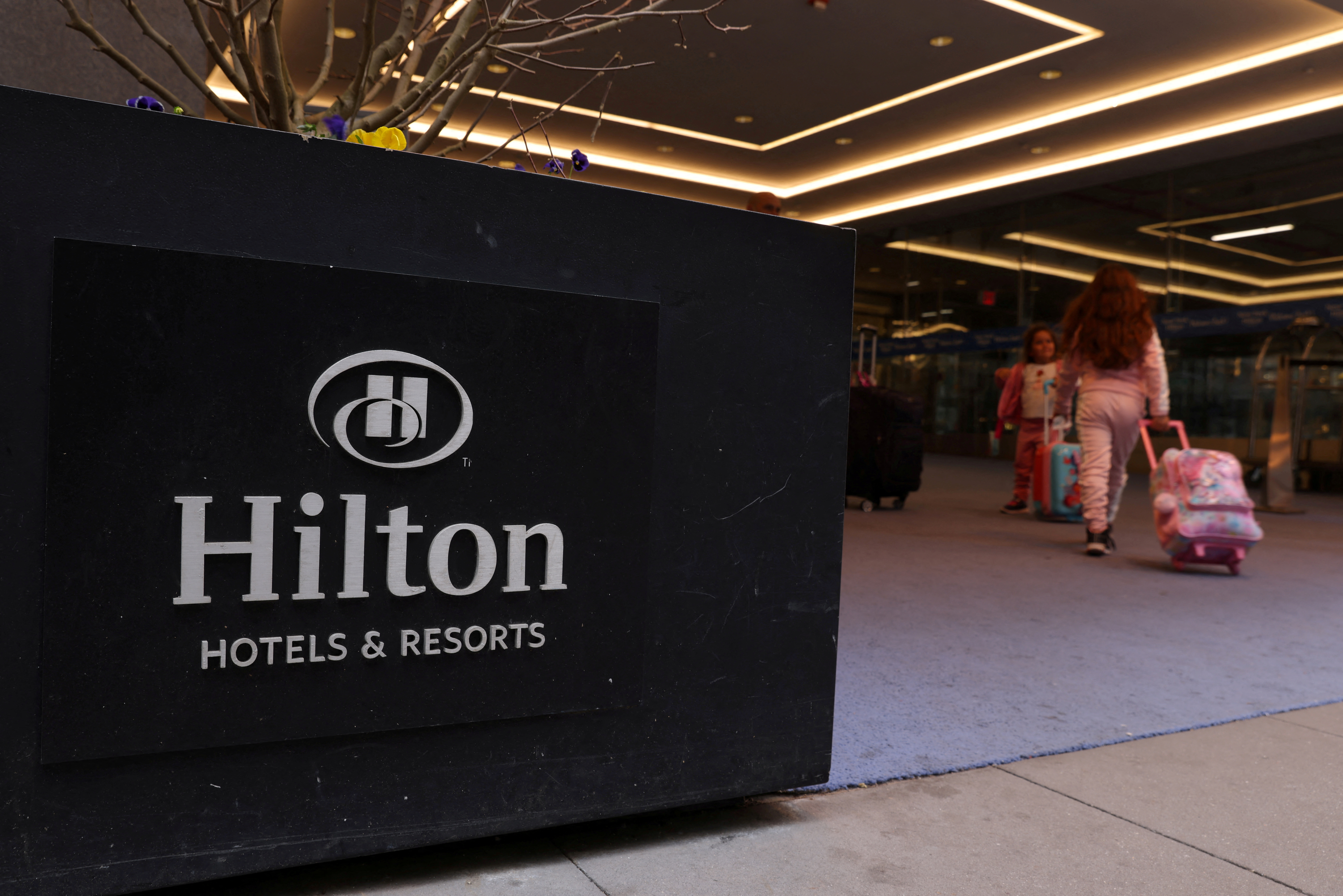People enter a Hilton hotel in Manhattan, New York City