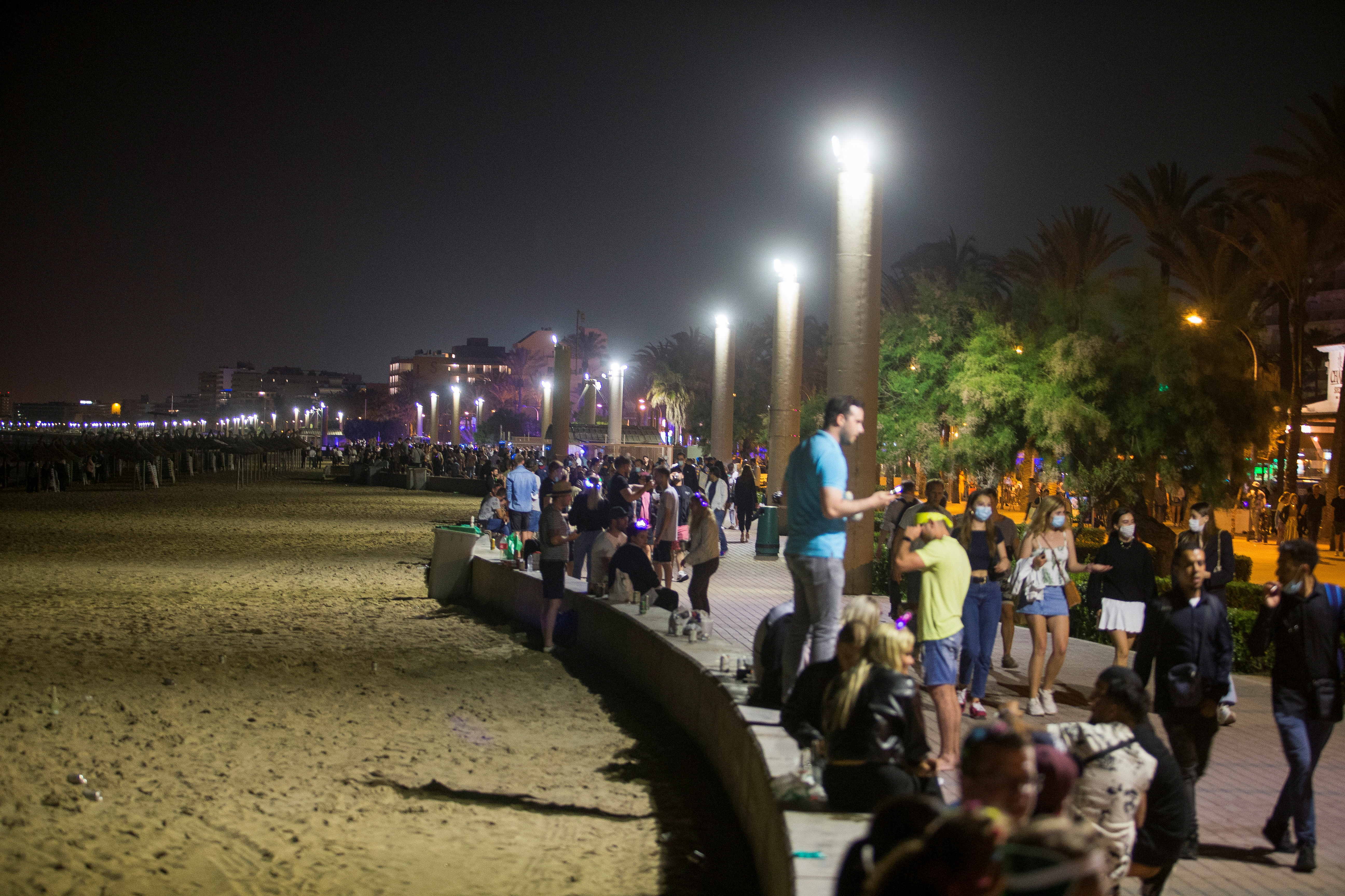 People party in Playa de Palma beach on the island of Mallorca, as Spanish regions with a low coronavirus disease (COVID-19) infection rate were allowed to reopen nightlife with some restrictions, in Mallorca, Spain, June 5, 2021. REUTERS/Enrique Calvo