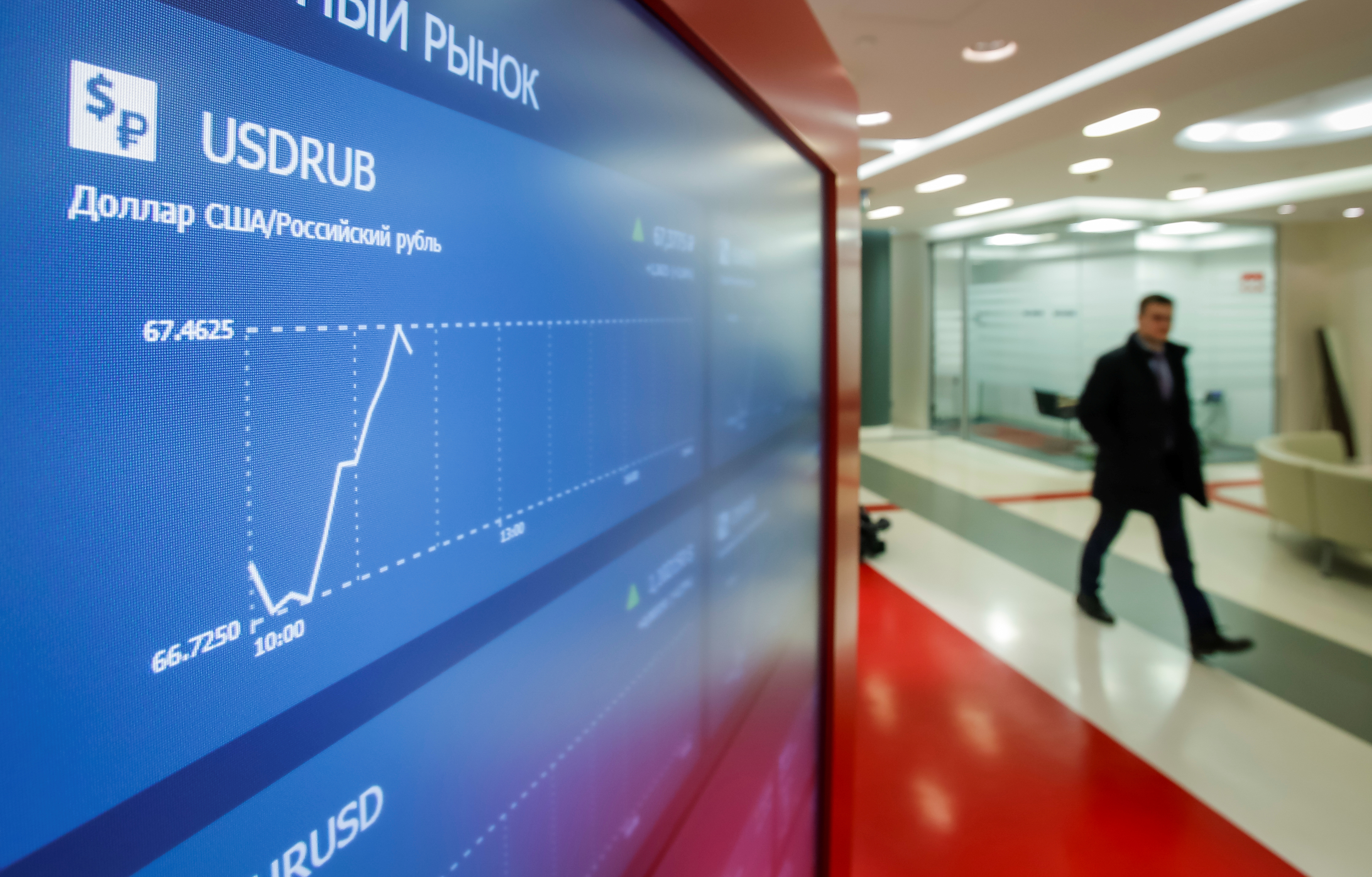 A man walks past an information screen inside the office of the Moscow Exchange in Moscow