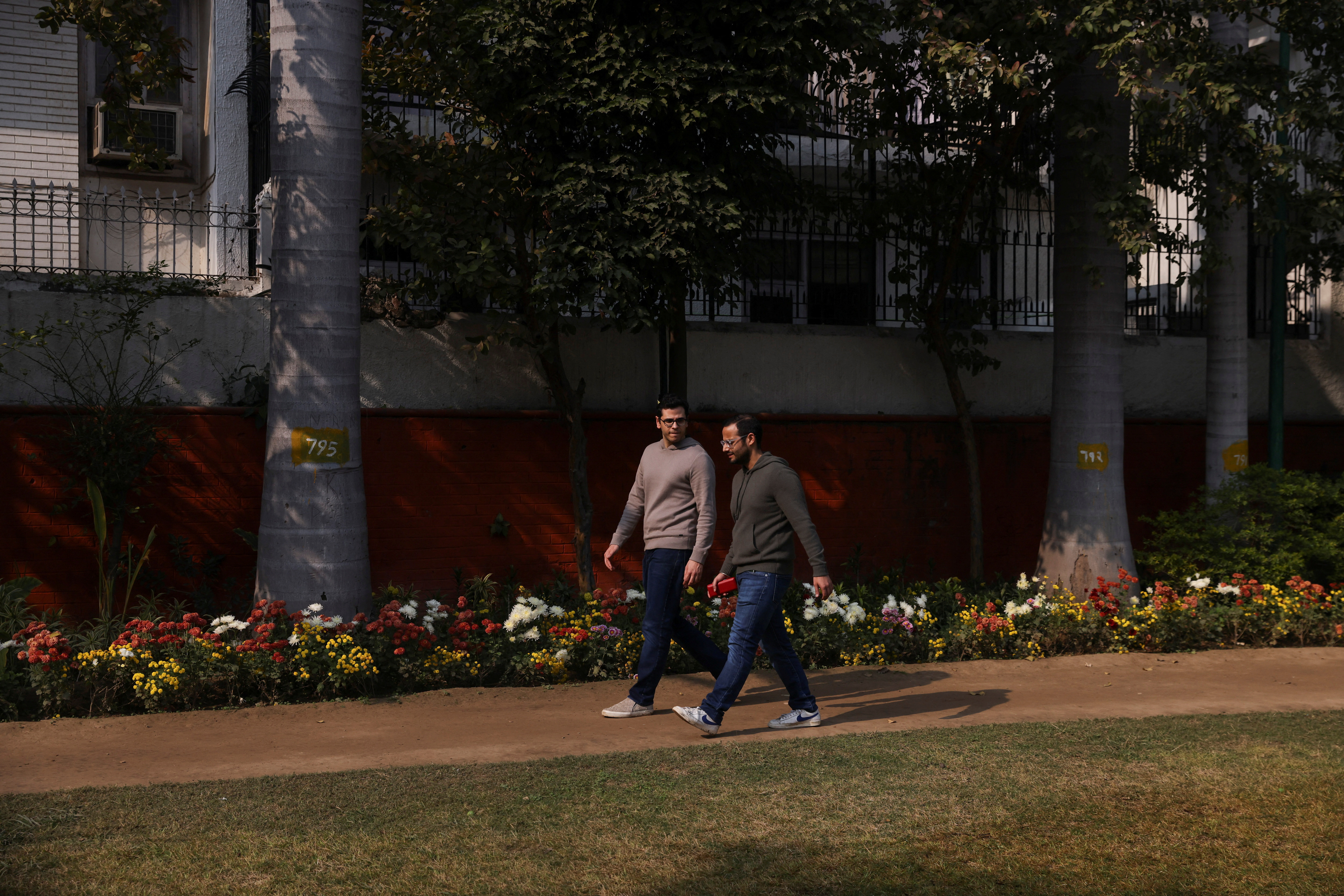 Parth Phiroze Mehrotra, 36, and his partner Uday Raj Anand, 35, walk in a park near their home in New Delhi