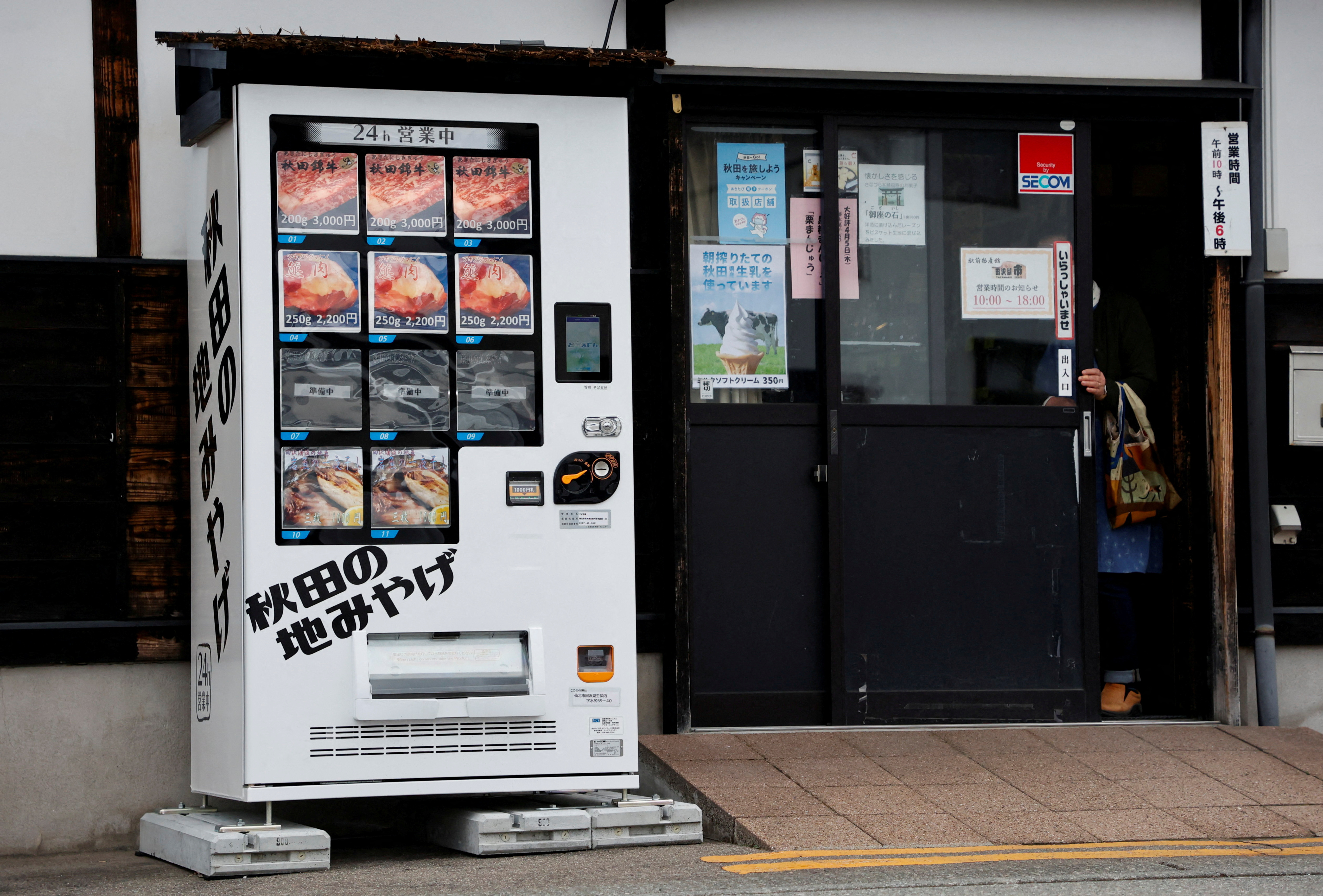 A vending machine menu offering Asian Black Bear meat, Akita Beef and dried mountain stream fish is seen in front of a Soba Noodle restaurant in Semboku