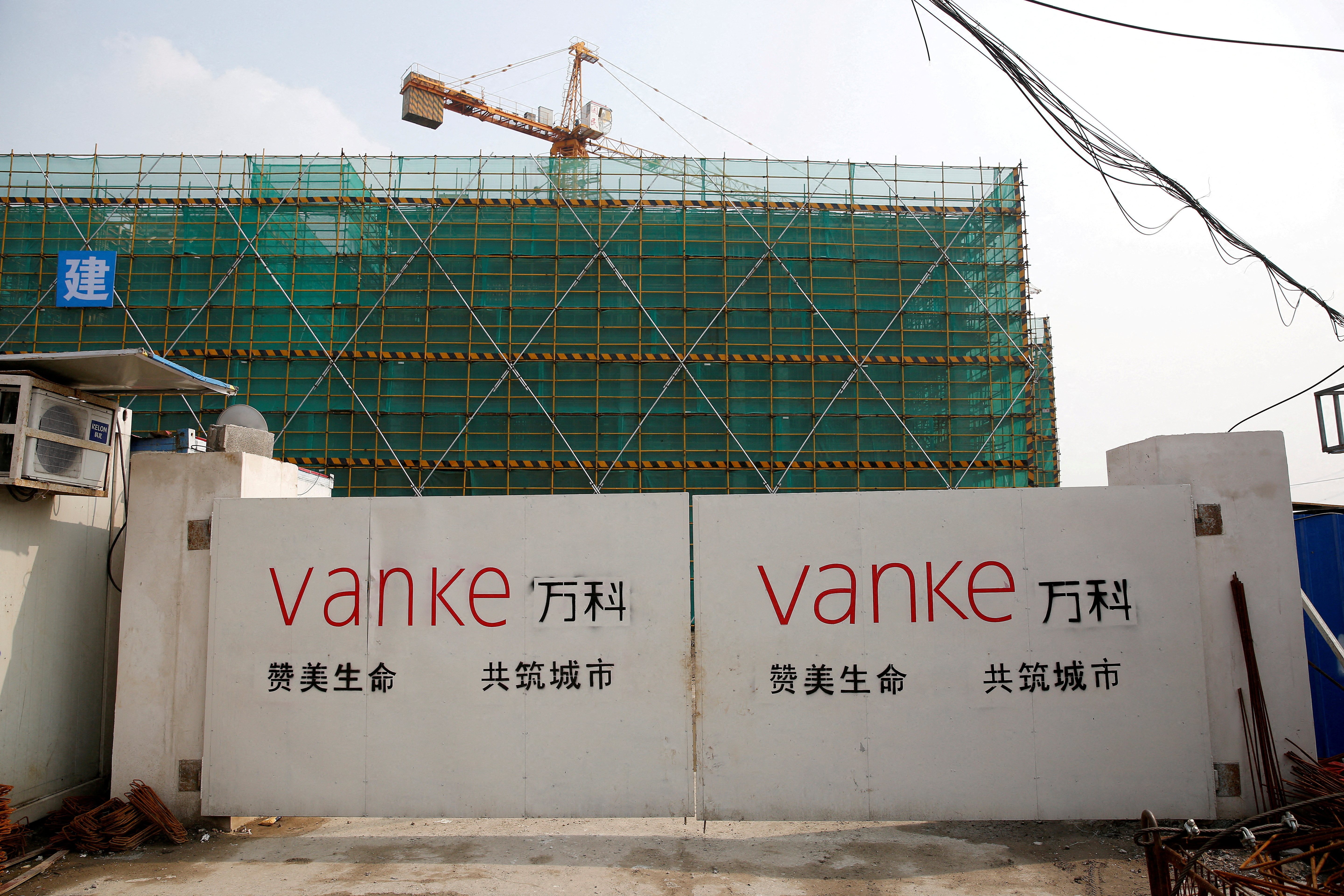 The logo of property developer China Vanke is seen on gates at a construction site in Shanghai
