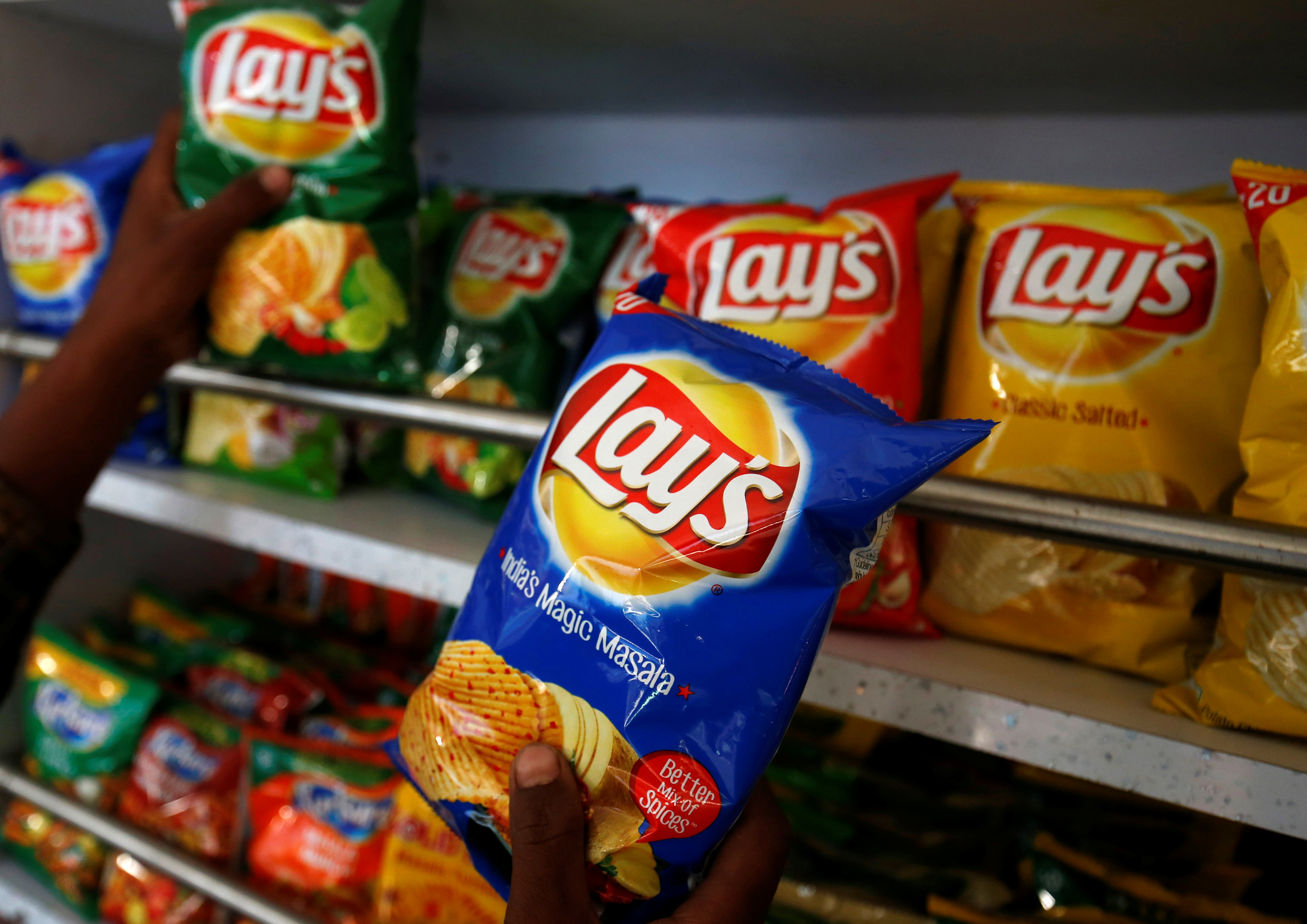 A customer picks packets of Lay's potato chips at a shop in Ahmedabad, India, April 26, 2019. REUTERS/Amit Dave