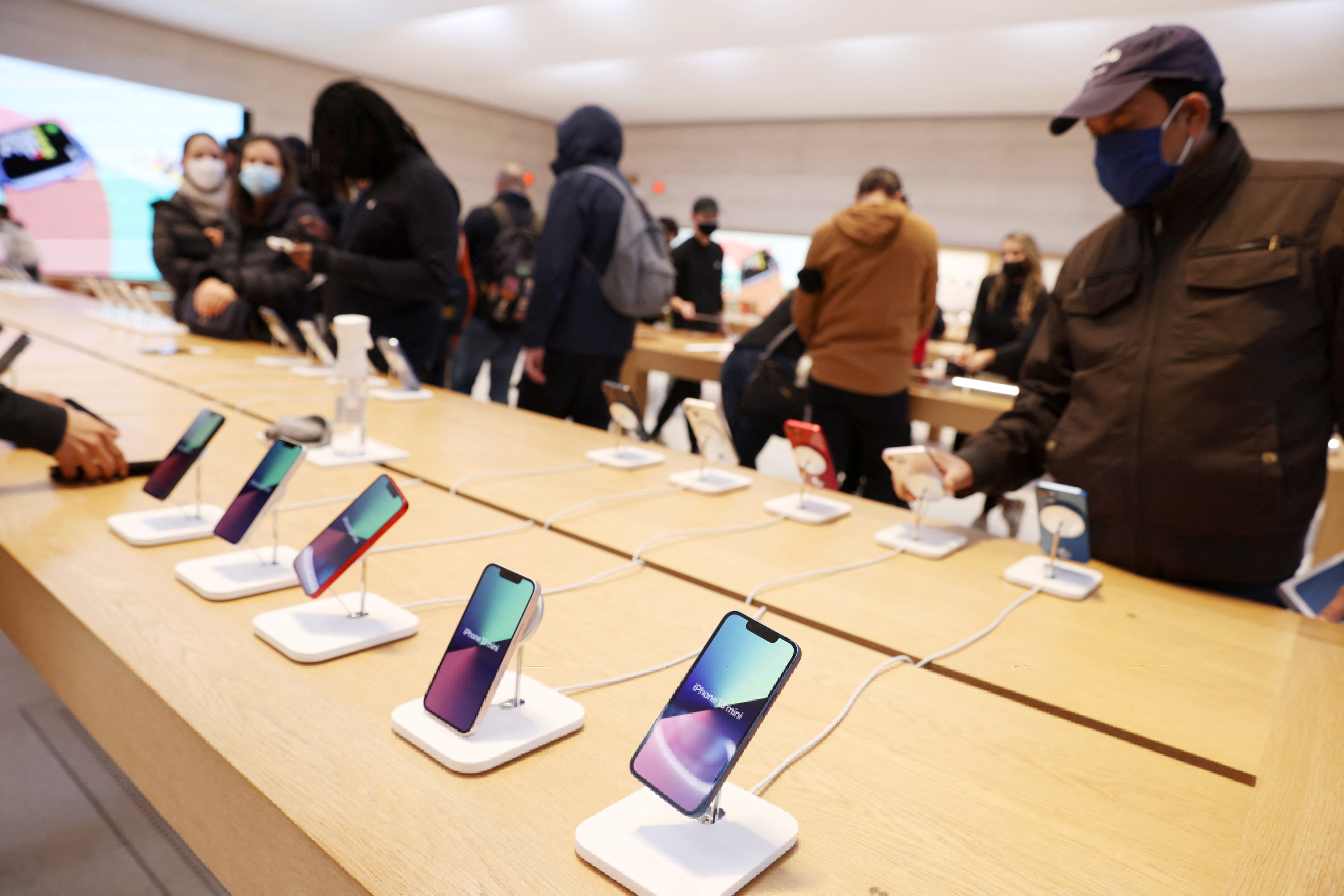 FILE PHOTO - People shop for smartphones in an Apple Store in Manhattan, New York City