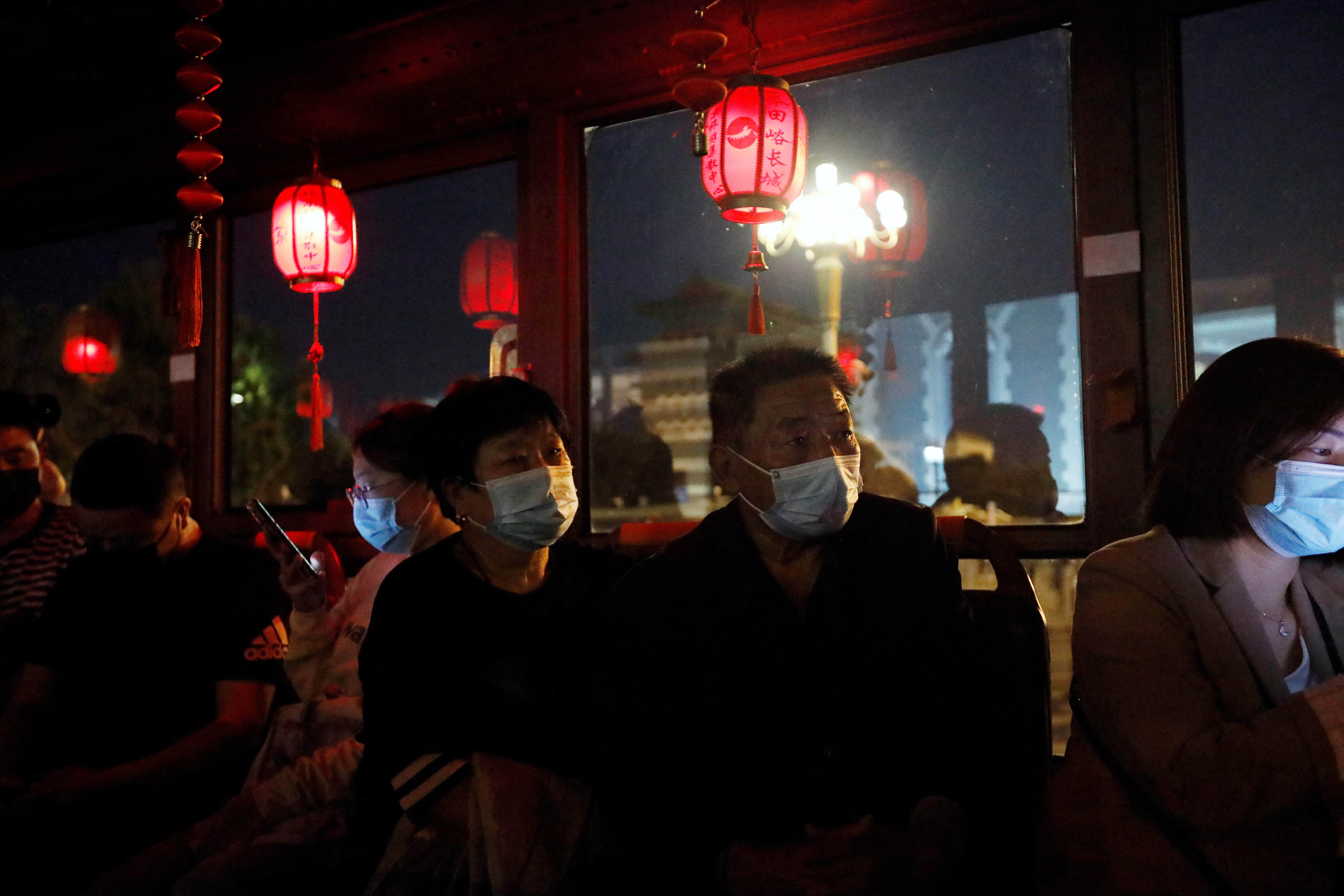 Passengers sit in a sightseeing bus in Beijing