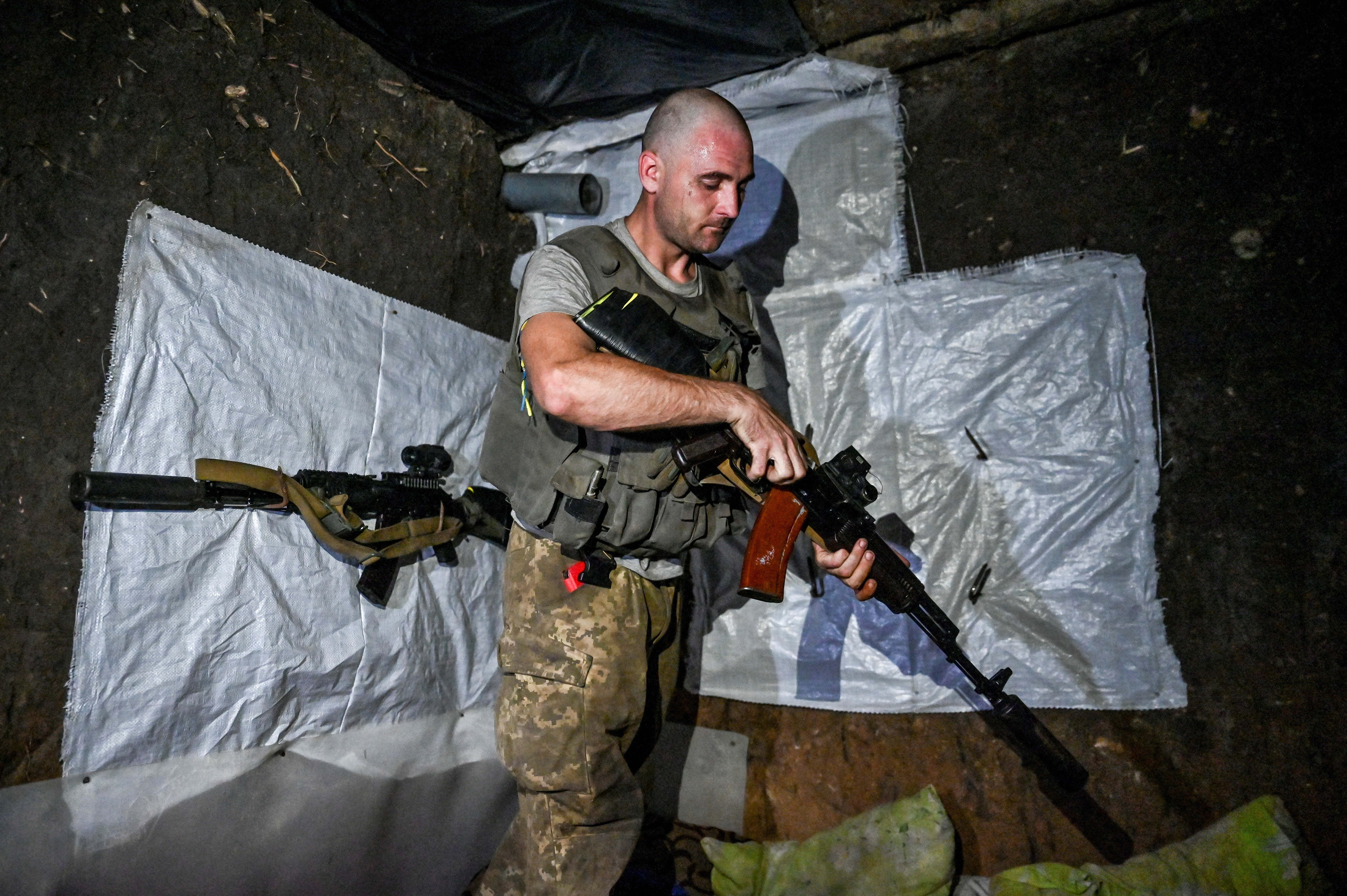 Ukrainian service member checks his weapon at a position near a frontline in Zaporizhzhia region