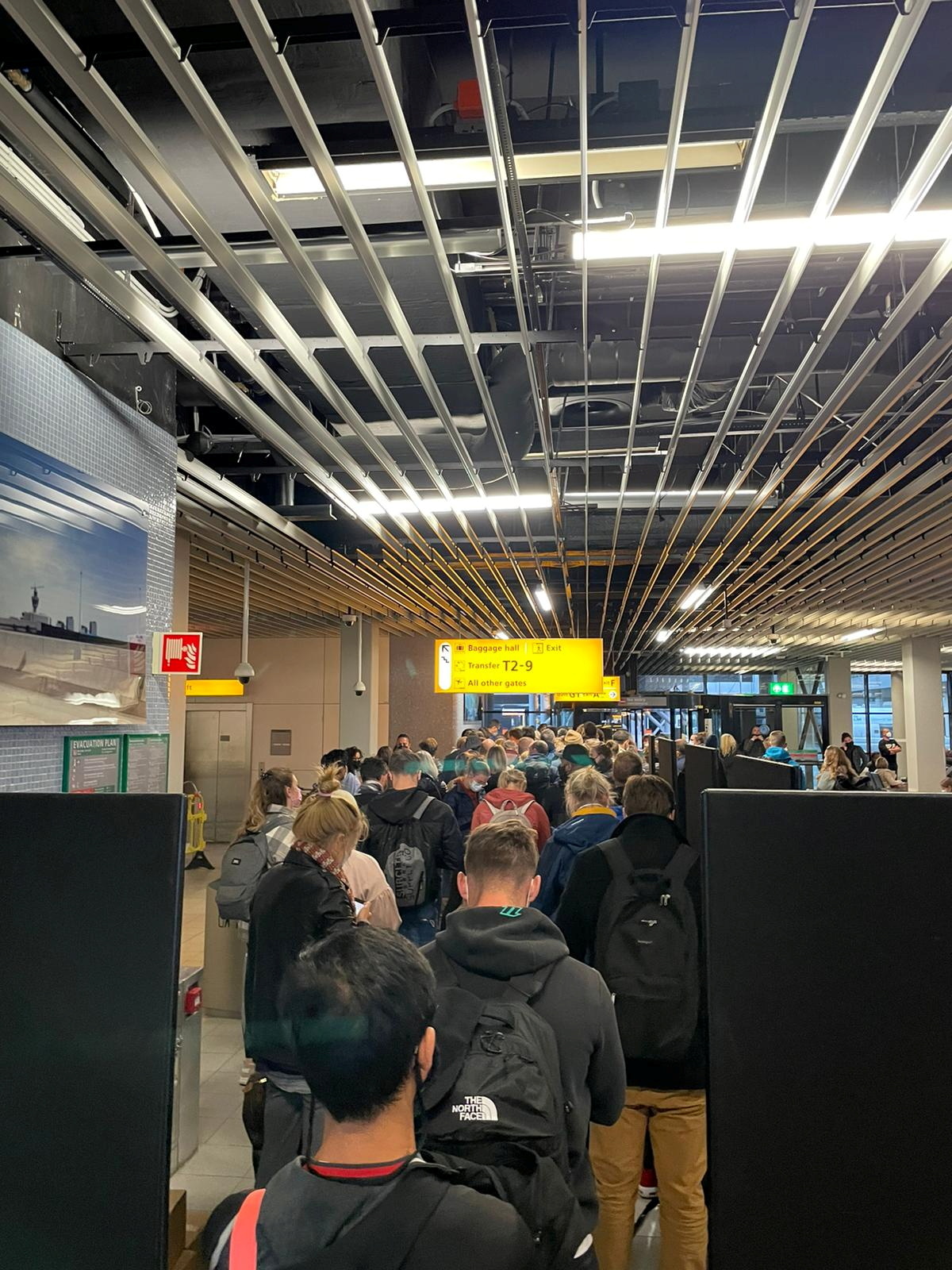 Passengers travelling from South Africa queue to be coronavirus disease (COVID-19) tested after being held on the tarmac at Schiphol Airport